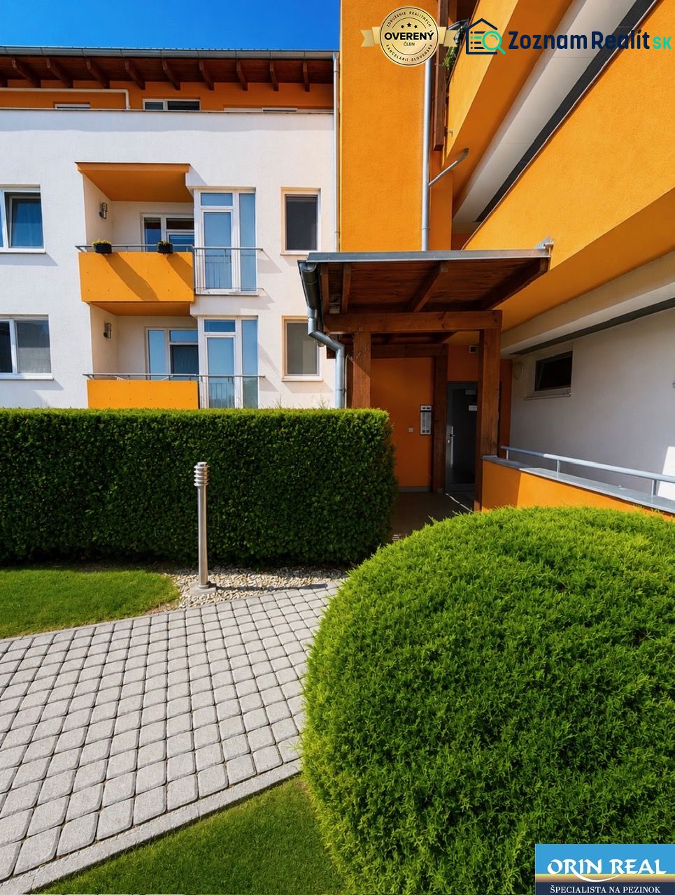 A colorful facade of a building surrounded by green shrubs on Cherry Street in Chorvátsky Grob.