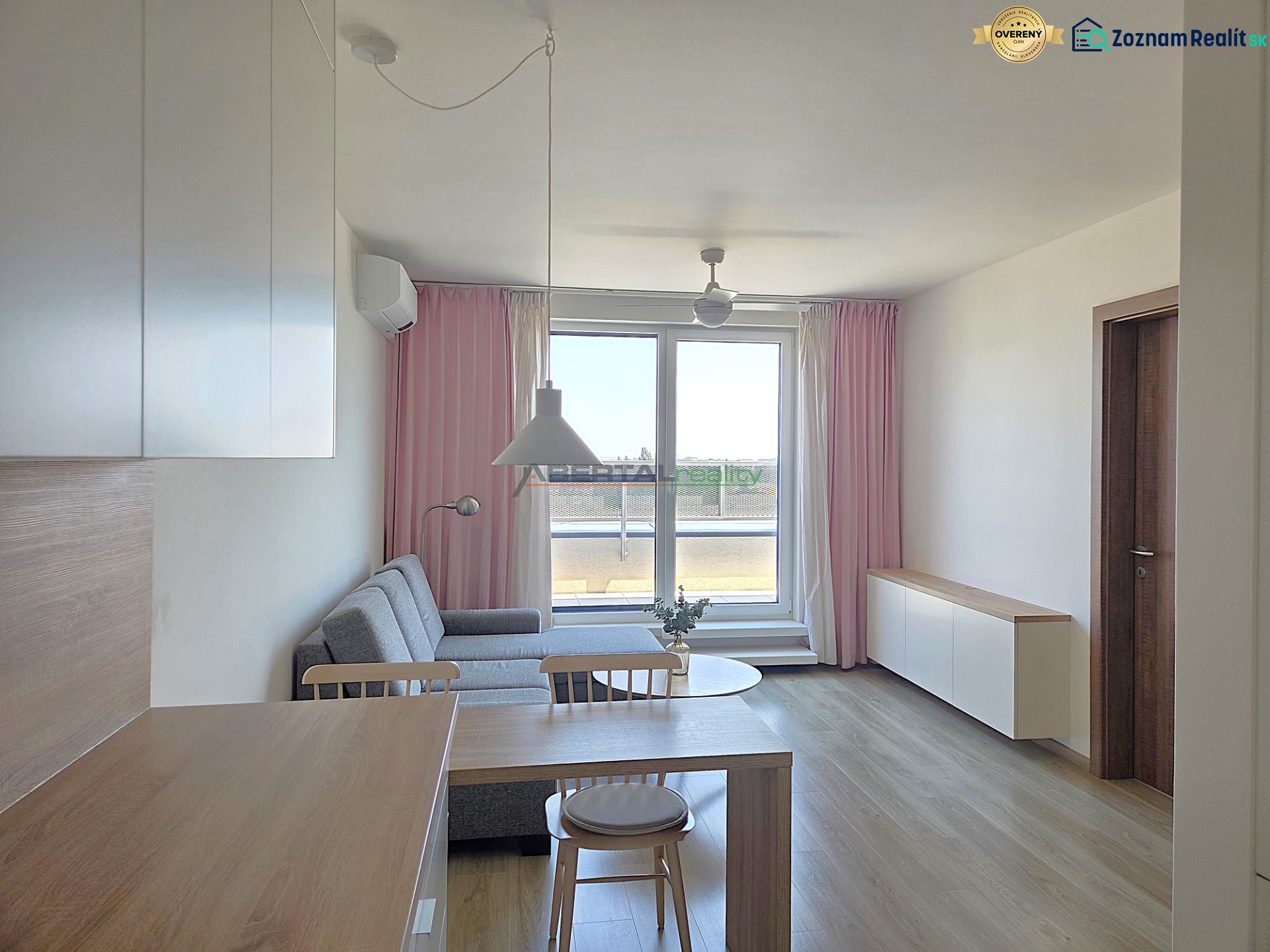 Living area of a 2-room apartment with a kitchen table and a wooden decor floor.
