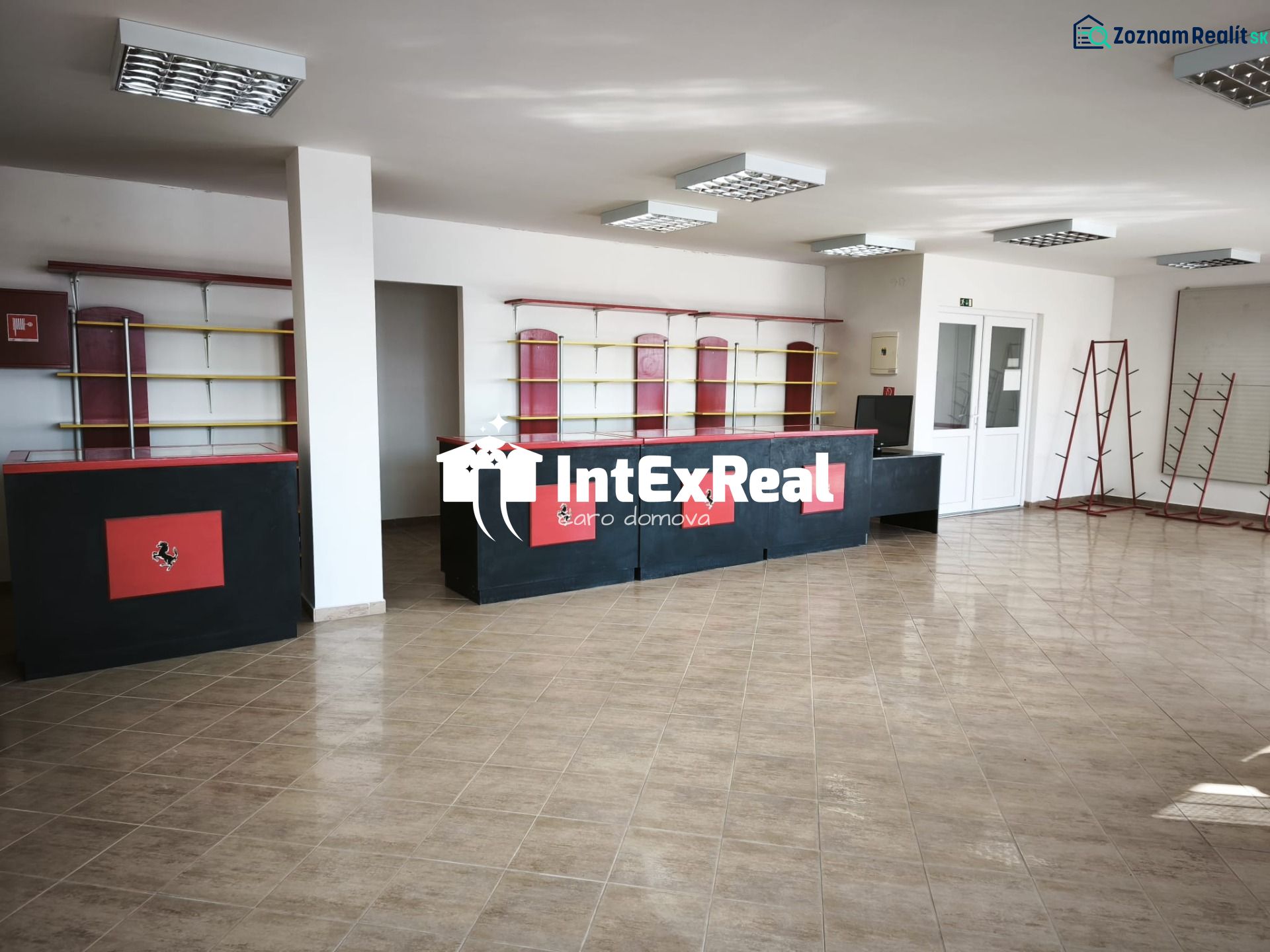 Commercial premises with tiles, black and red counters, shelves, and racks.