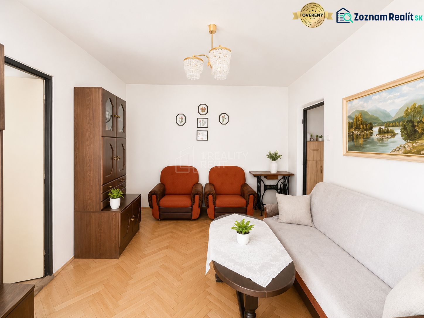 Living room with wood-patterned flooring, furniture, and paintings in a 3-room apartment.