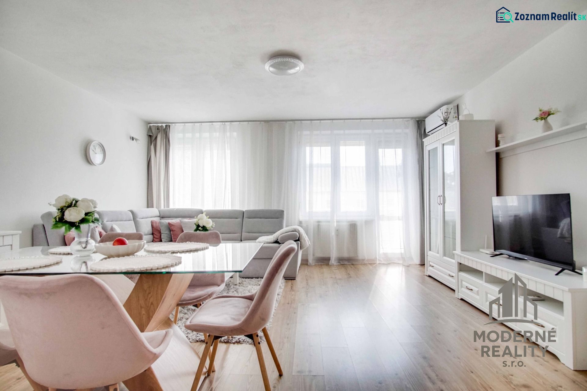 A bright living room in a two-room apartment with a wooden decor floor, stylish furniture, and decorations.