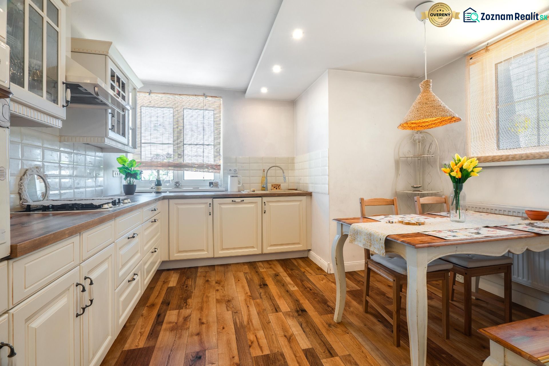A kitchen in a 4-room apartment with a wooden decor floor and a dining area.