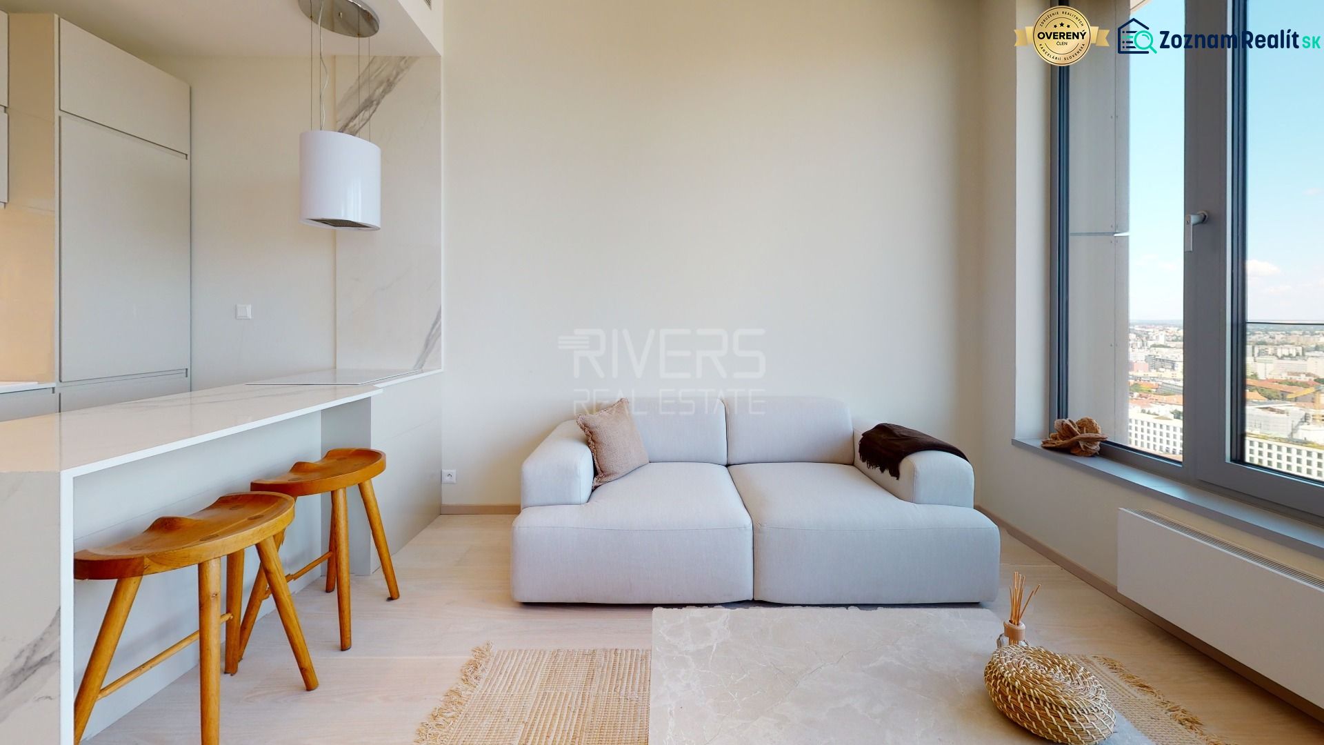Living room in a 2-room apartment with a sofa, bar counter, and city view.