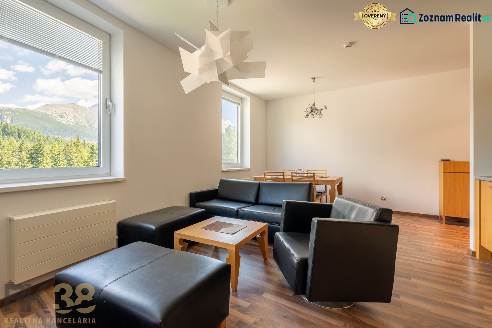 Interior of a holiday apartment with sofas, a dining table, and a wooden decor floor.