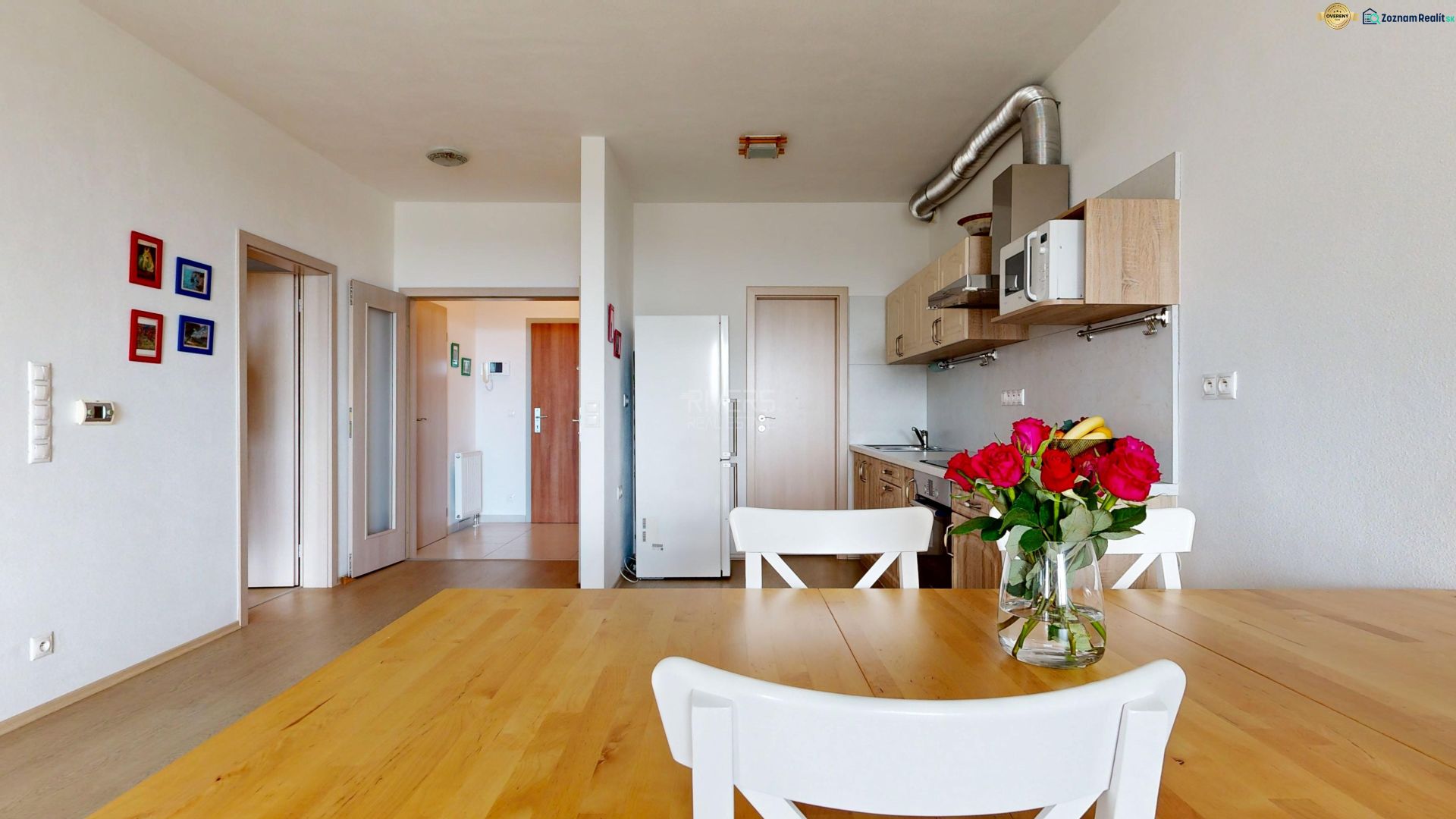 A kitchen with a wooden table and a decorative floral arrangement in a two-room apartment.