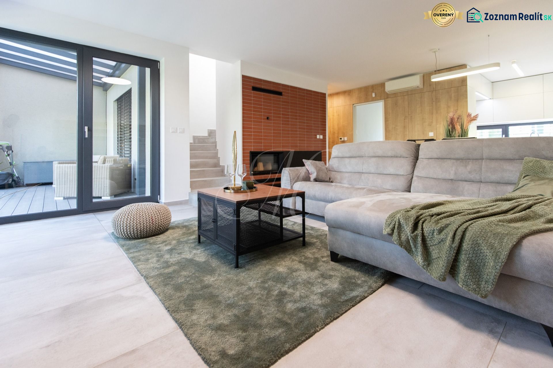 A spacious living room with a sofa, carpet, and transparent doors in a 4-room apartment.