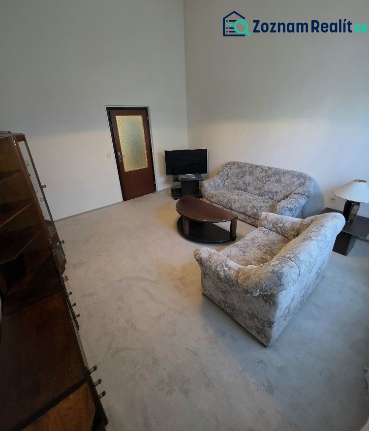 Living room with a sofa, table, and television in a three-room apartment.