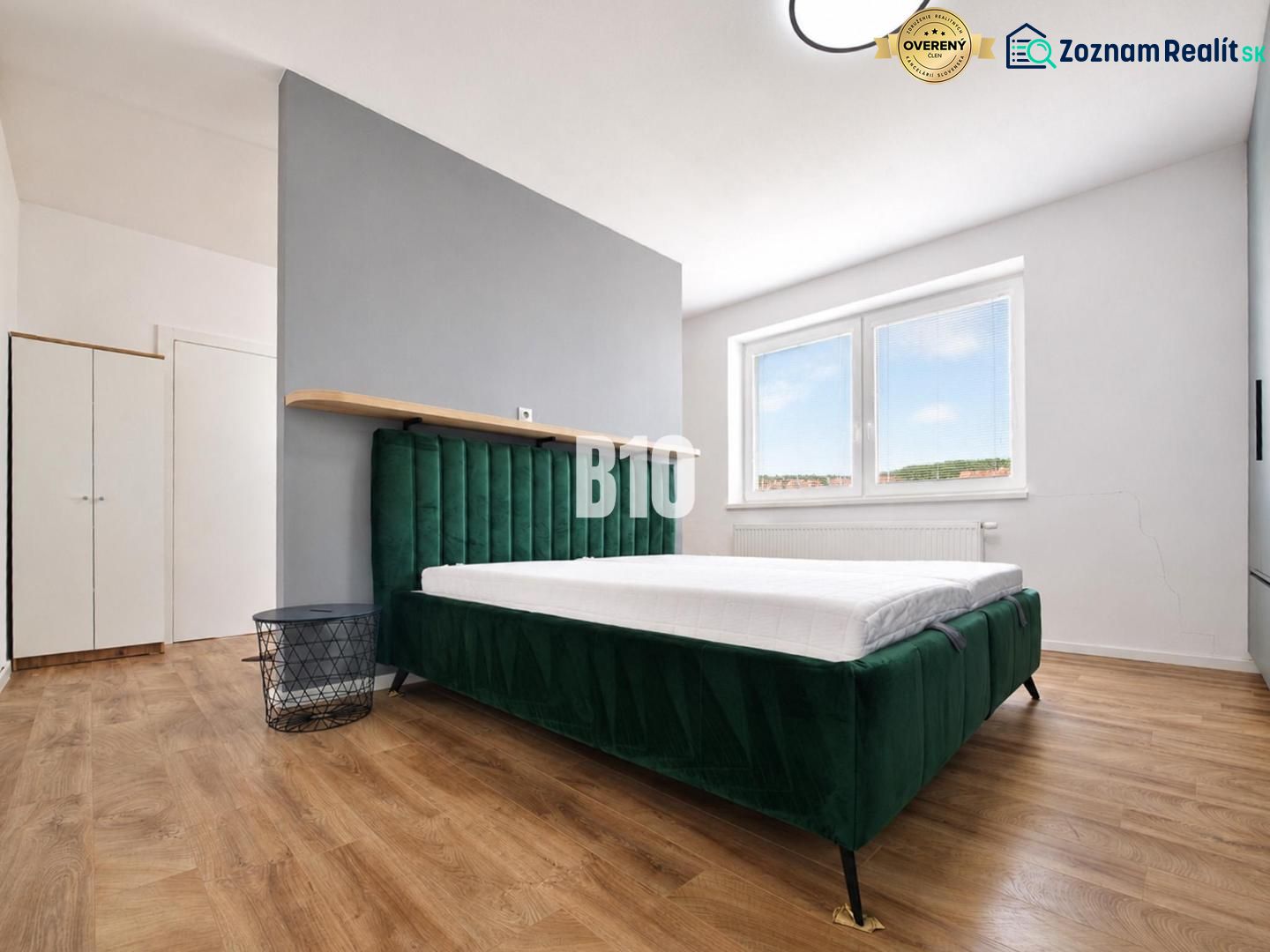 A bedroom in a holiday apartment with a bed and a wooden decor floor.