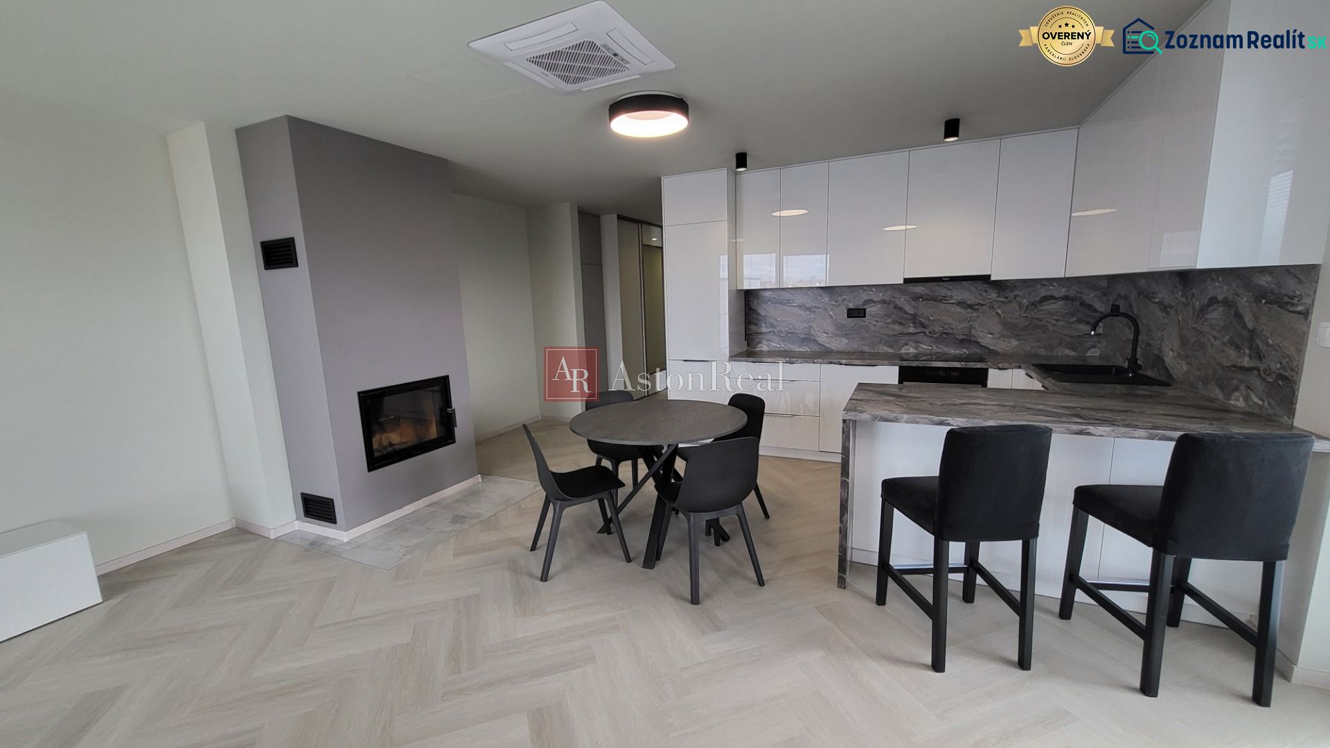 Living room of a three-room apartment with a wooden decor floor and a kitchenette.