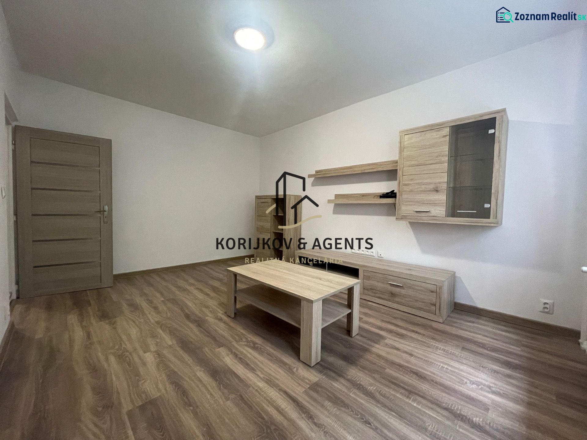 Living room in a two-room apartment with wood-decor furniture and a wood-patterned floor.