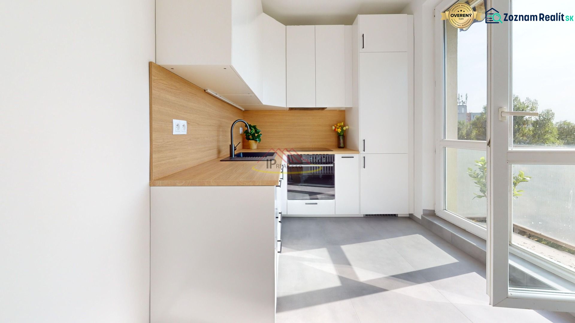 A kitchen in a 3-room apartment with white cabinets and a wood-patterned floor.