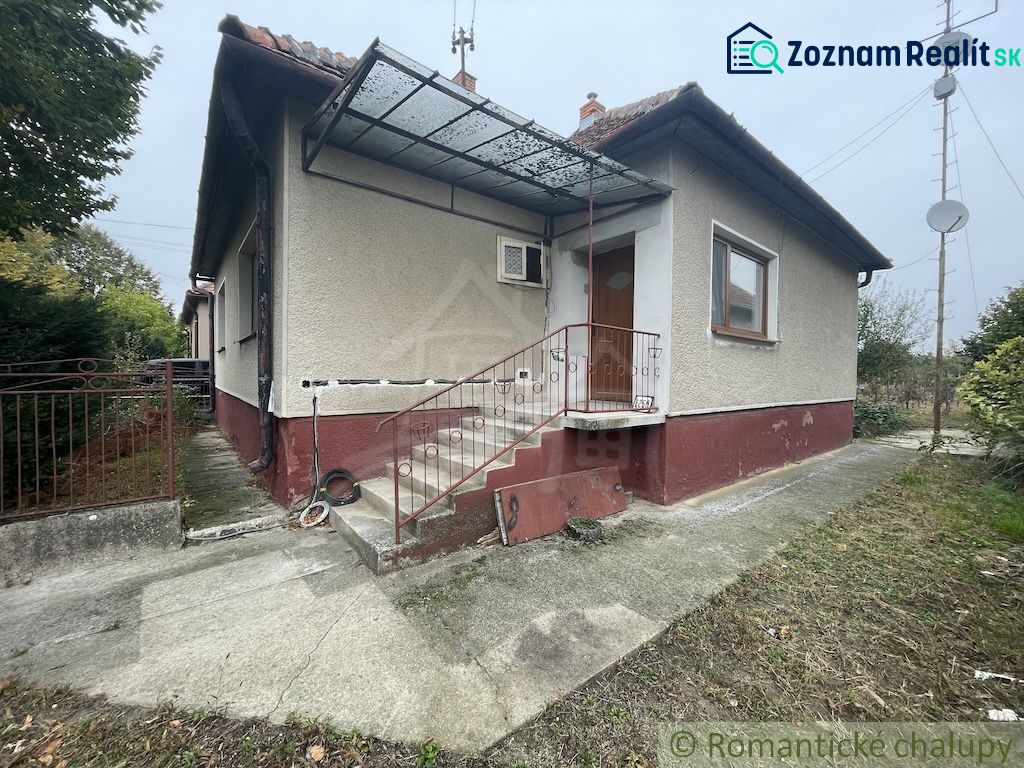 A family house in Šurany with plaster, metal railing, and a metal roof.