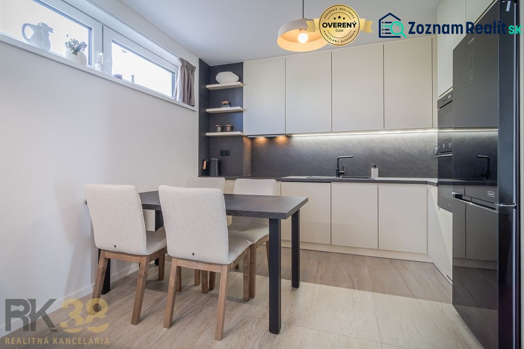 Kitchen in a 4-room apartment, wooden decor flooring, light cabinets, and a dining table.