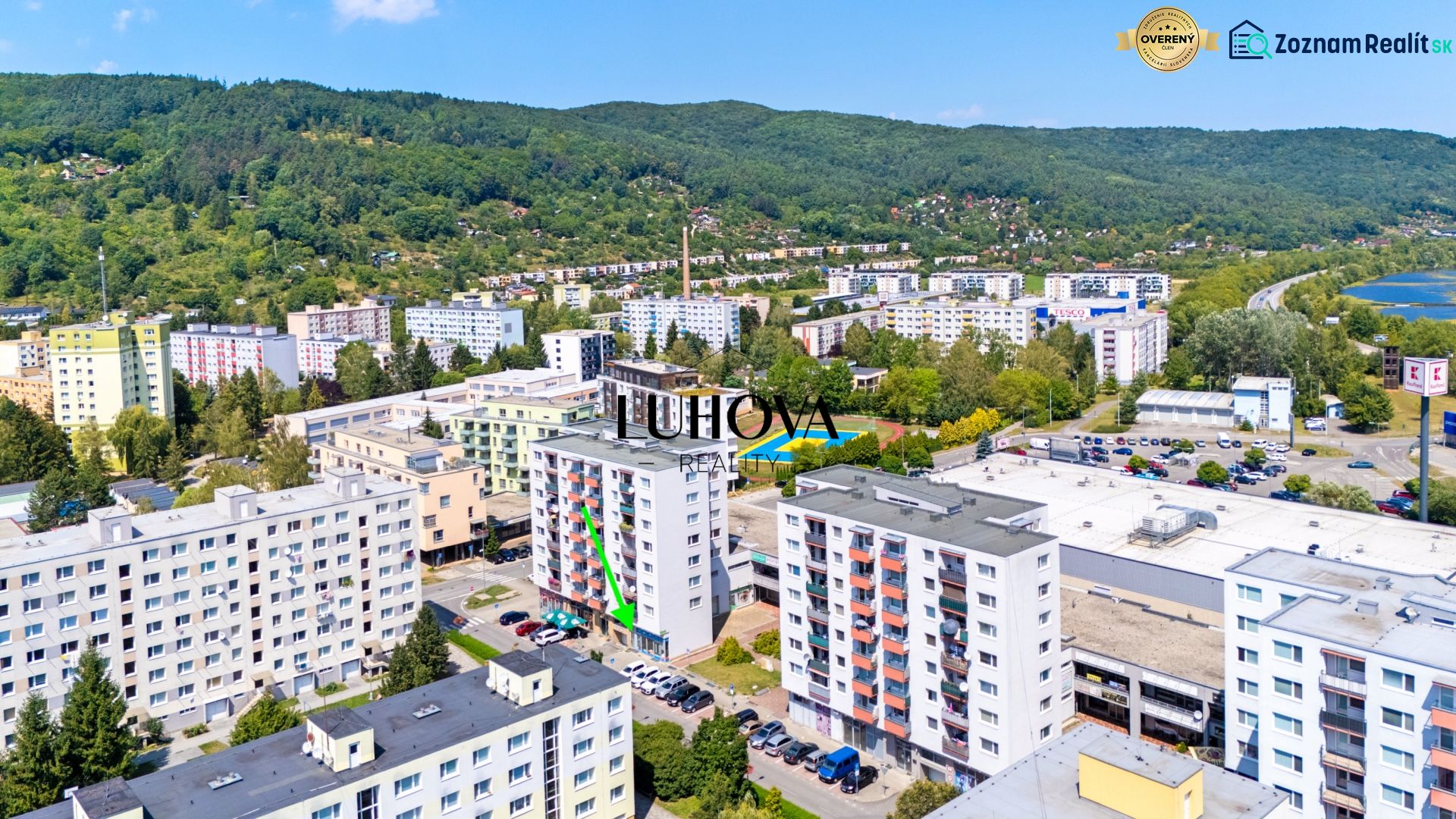 A view of the commercial premises at Dvory in Púchov with nearby greenery and rooftop parking.