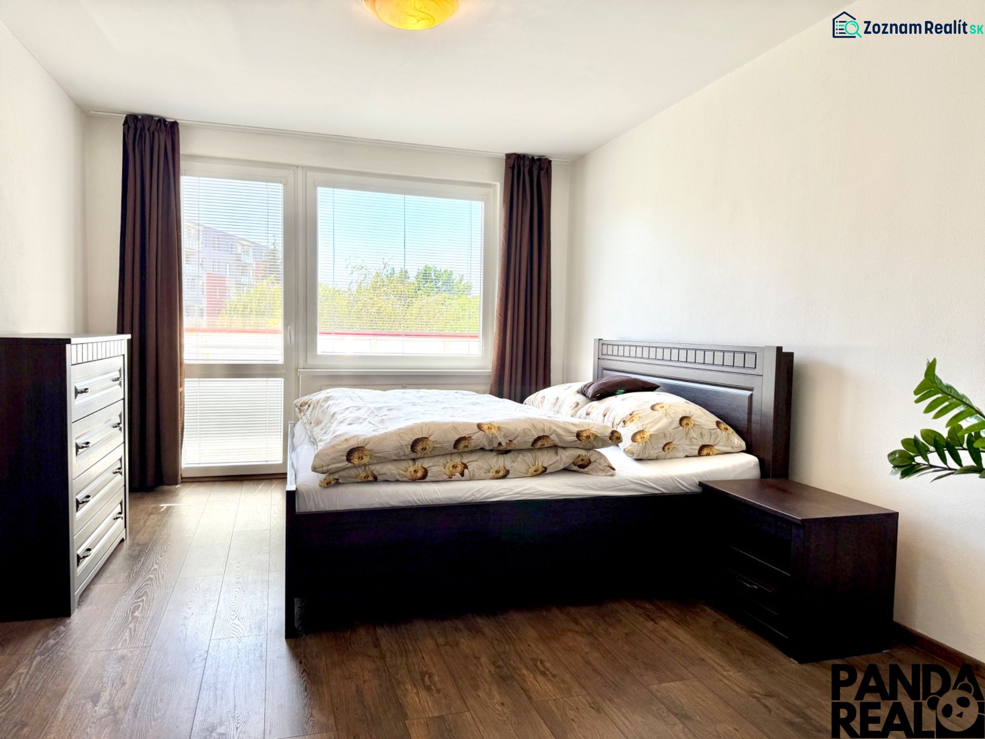 Bedroom with a bed and a dresser, wooden decor flooring, in a studio apartment.