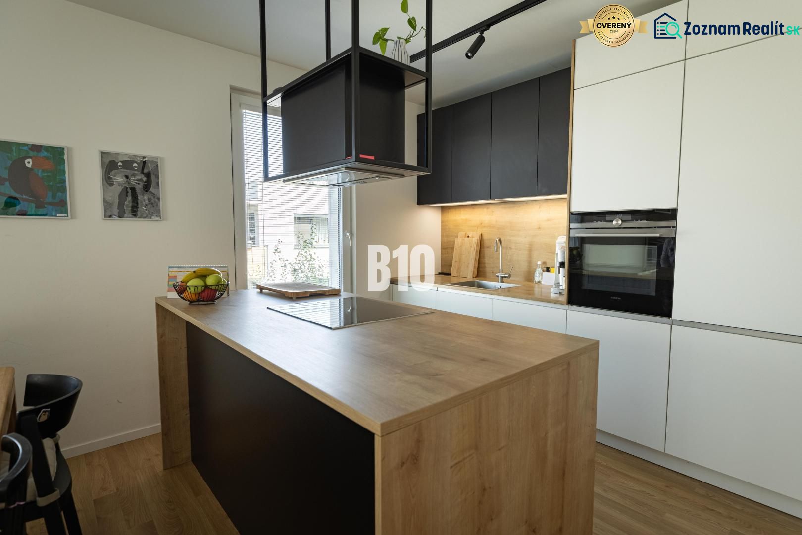 A kitchen in a 3-room apartment with an island and a wooden decor floor.