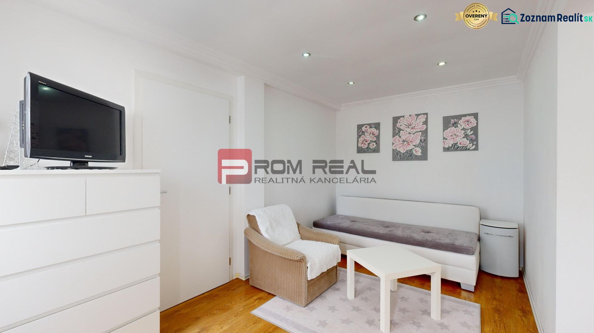 Living room with white furniture, a sofa, a television, and a floor with a wooden decor.