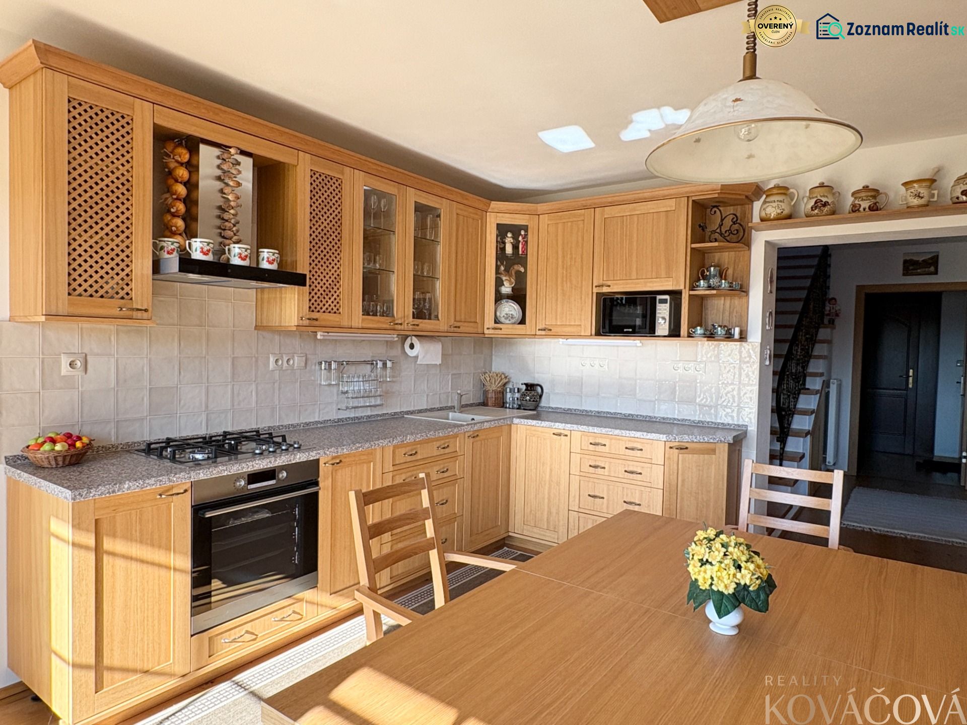 A kitchen in a family house with wooden cabinets and light walls.