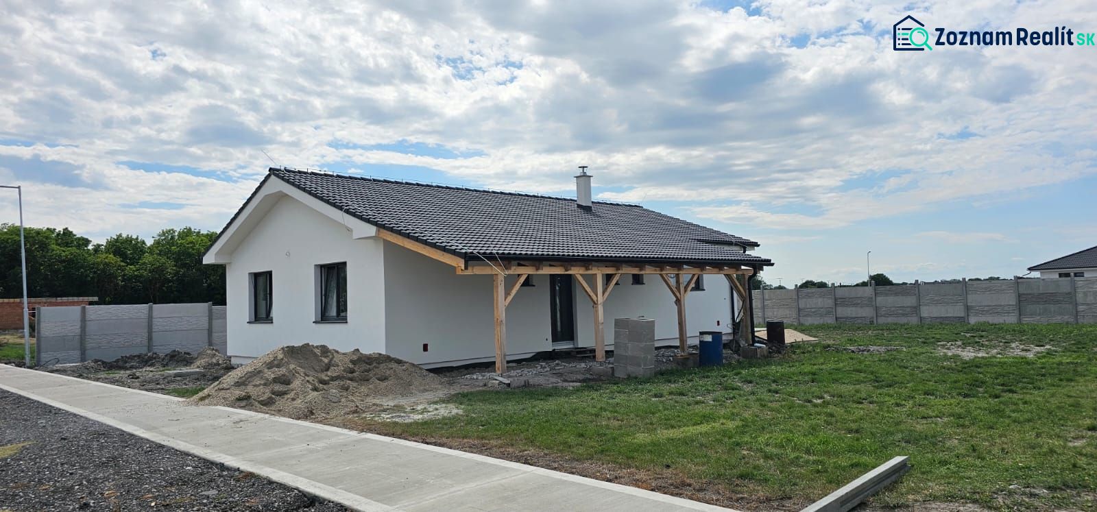 A family house in Bellova Ves with a shelter and a garden, surrounded by a fence.