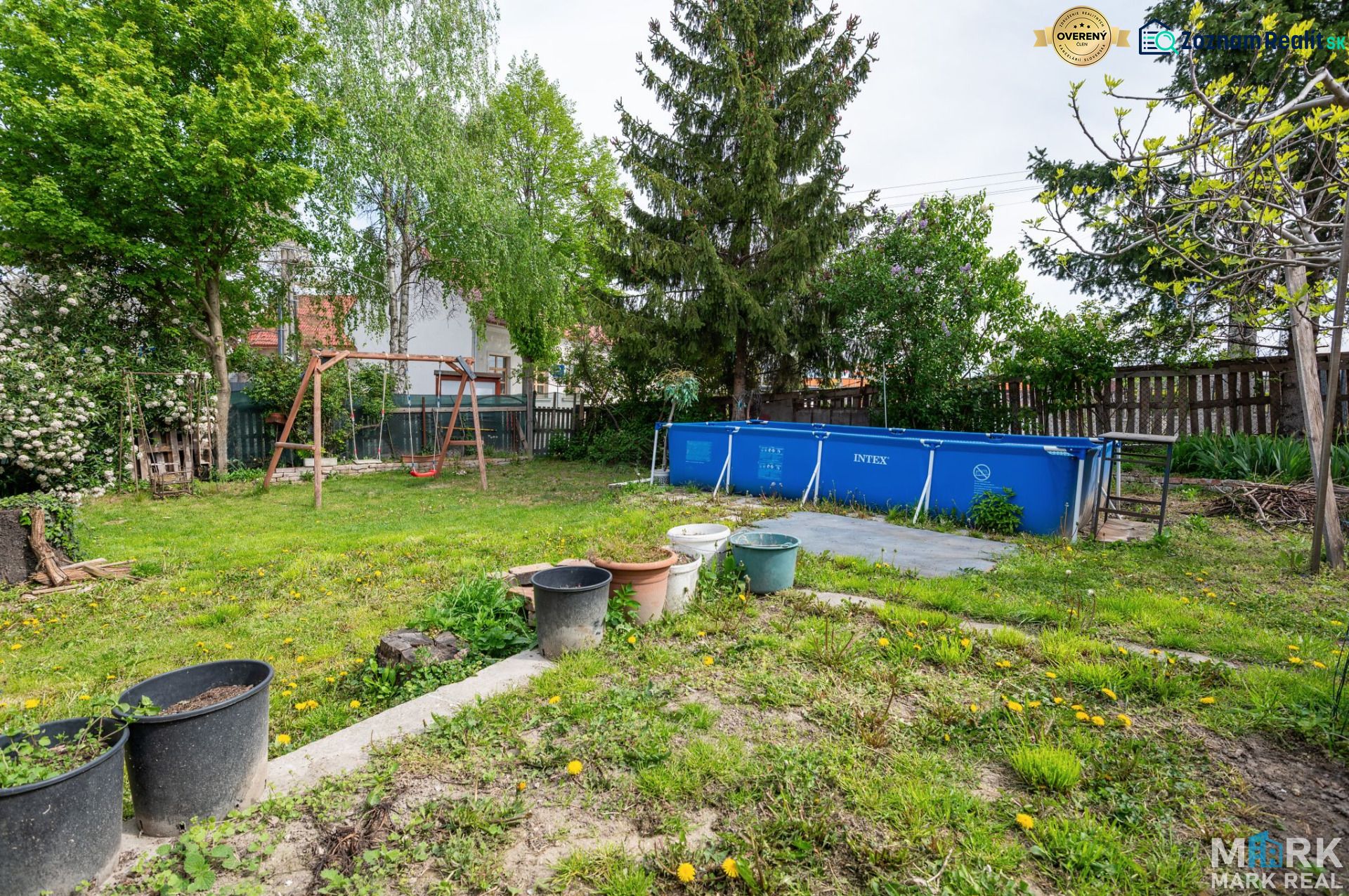 A garden with a swimming pool and a swing on a residential plot in Dunajská Lužná, Kováčska.