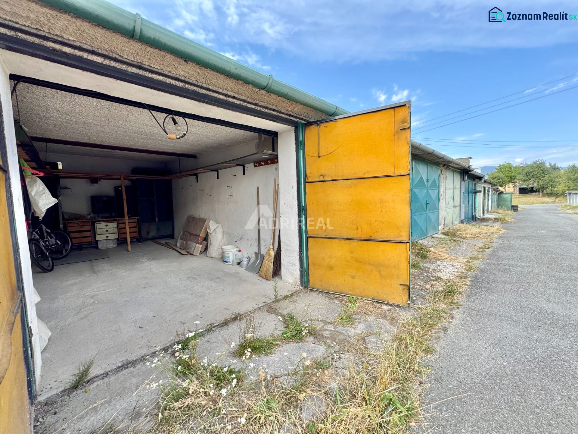 Open garage in Detva with a concrete floor and storage space.