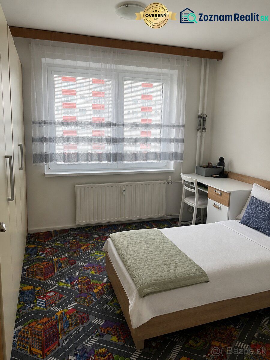 Single bed in a 3-room apartment with a creative carpet and a work desk.
