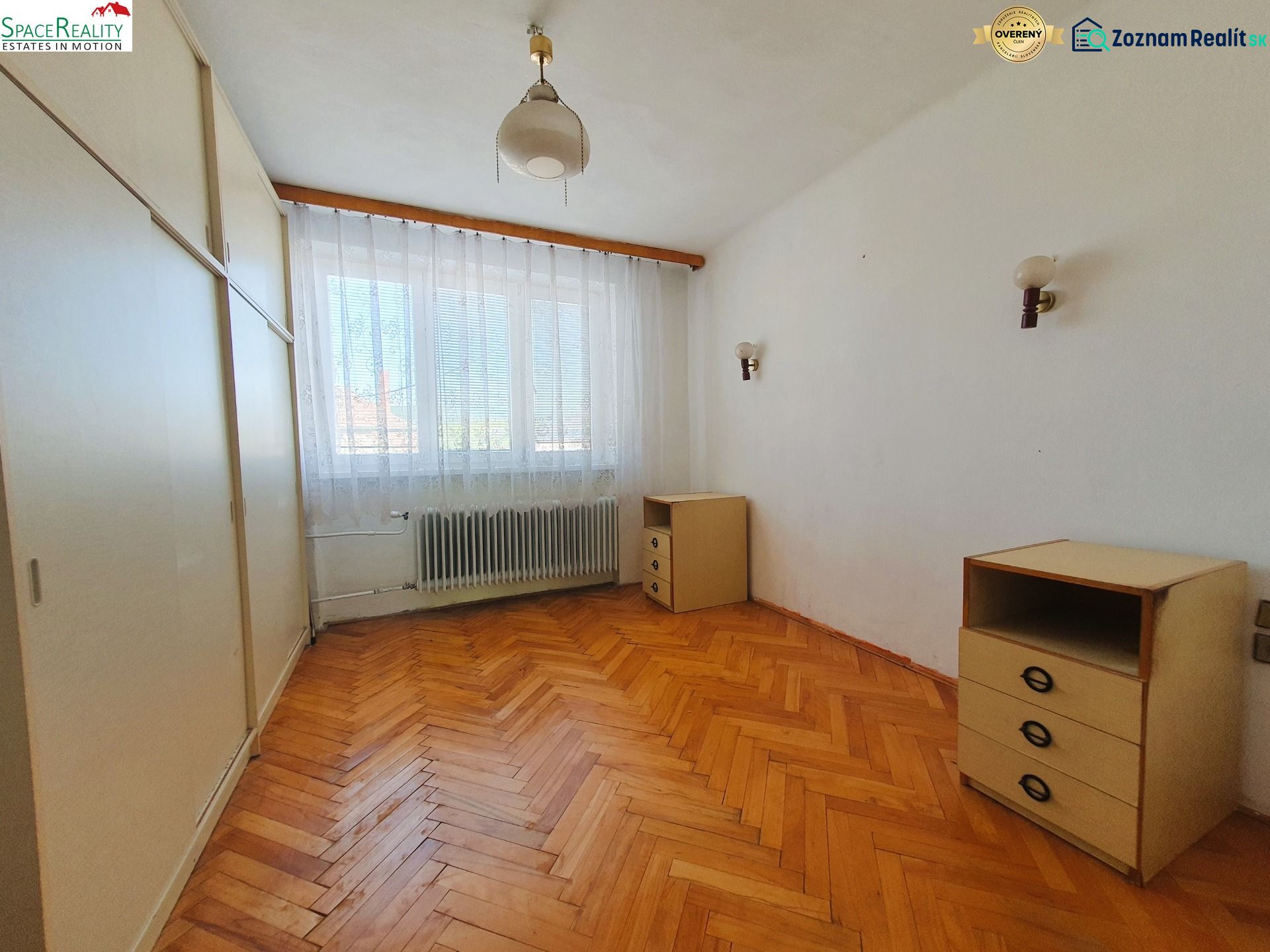 A room in a 3-room apartment with a floor featuring a wooden decor and white walls.