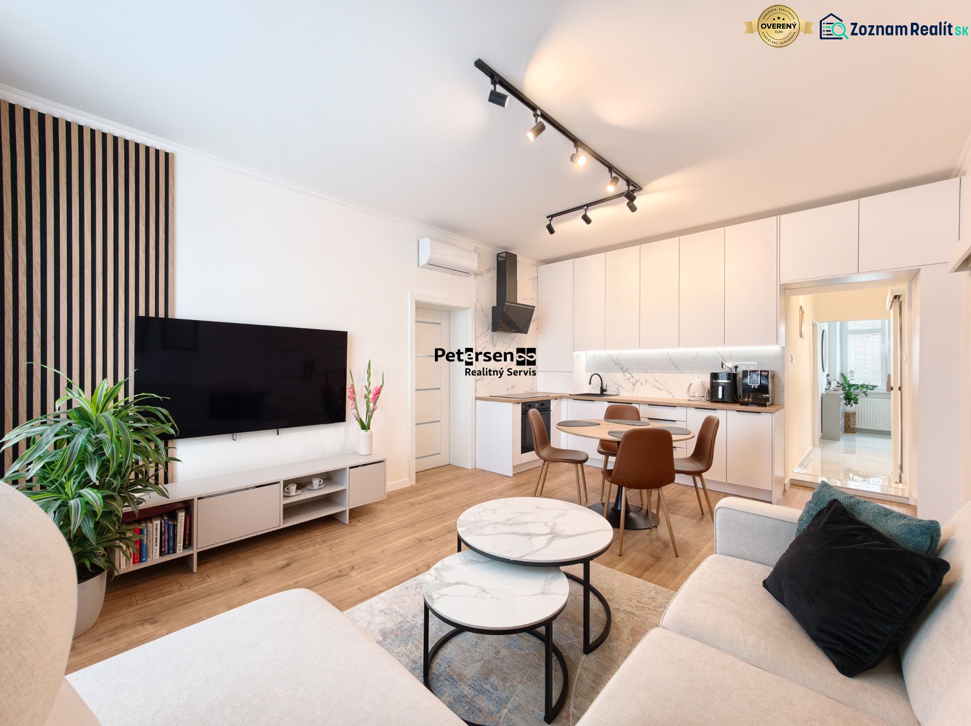 Living room with kitchen in a 3-room apartment, white cabinets, floor with wood decor.