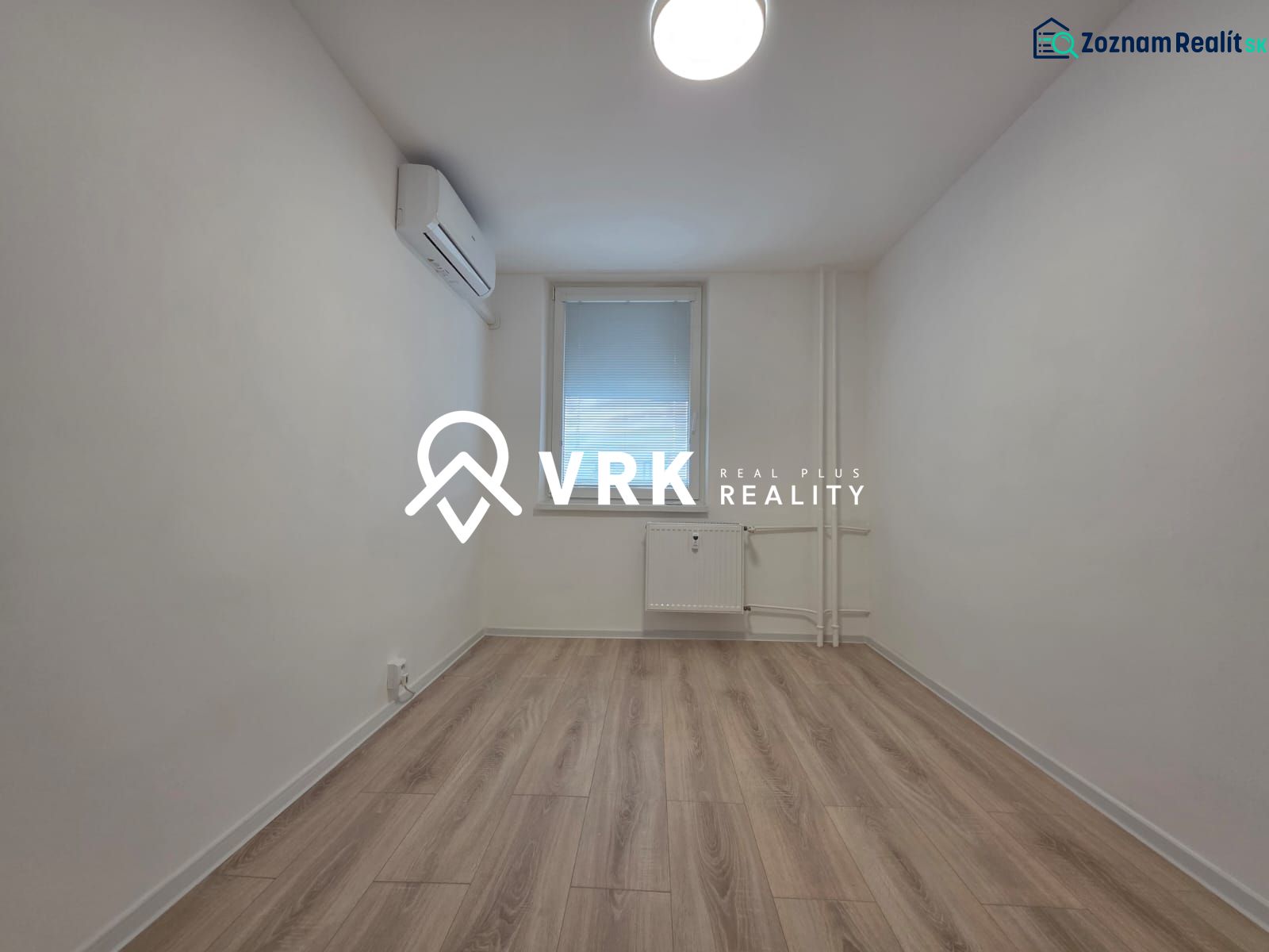 A room with air conditioning and a wooden decor floor in a 3-room apartment.