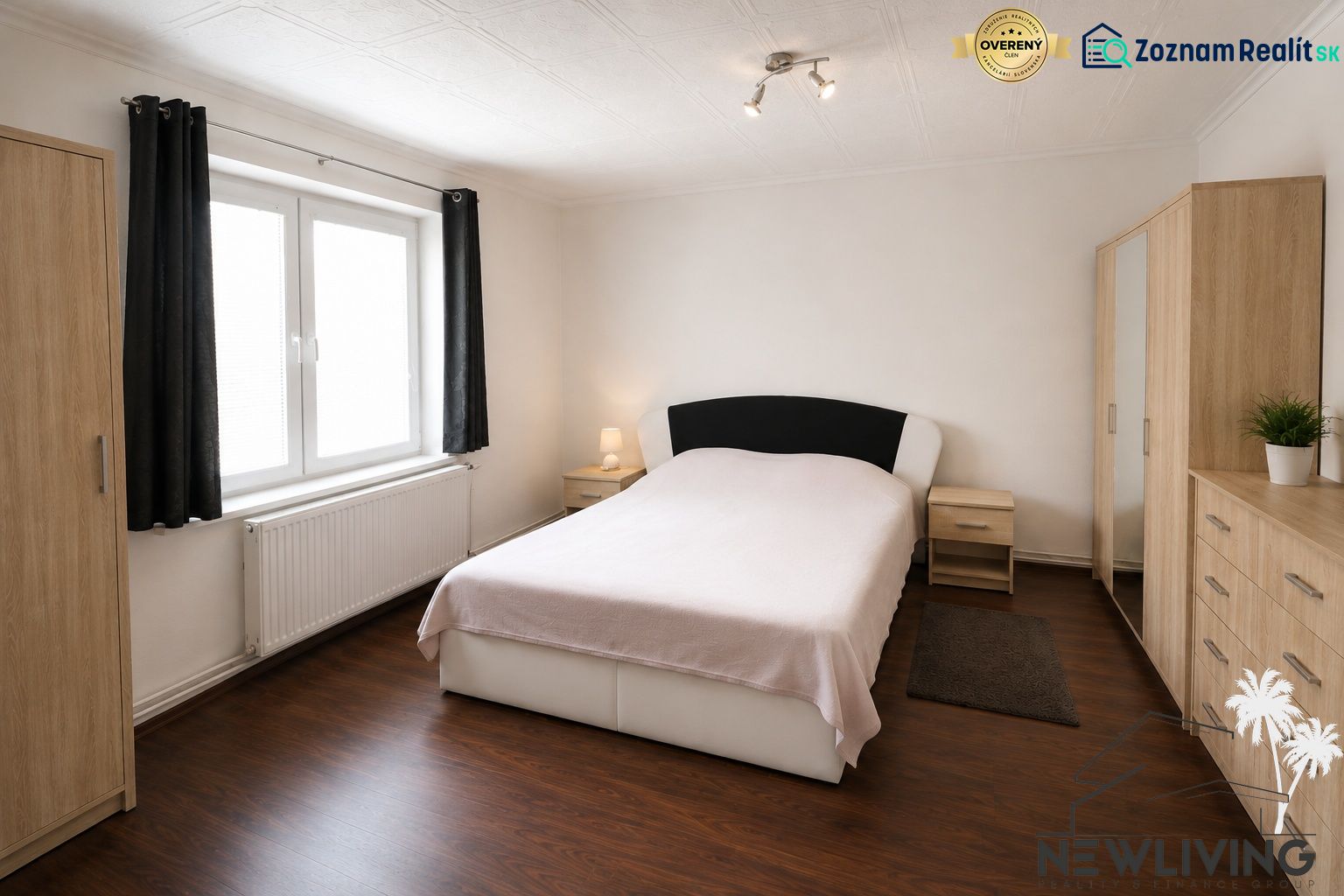 A bedroom in a family house with a wood-patterned floor, light, and furniture in neutral colors.