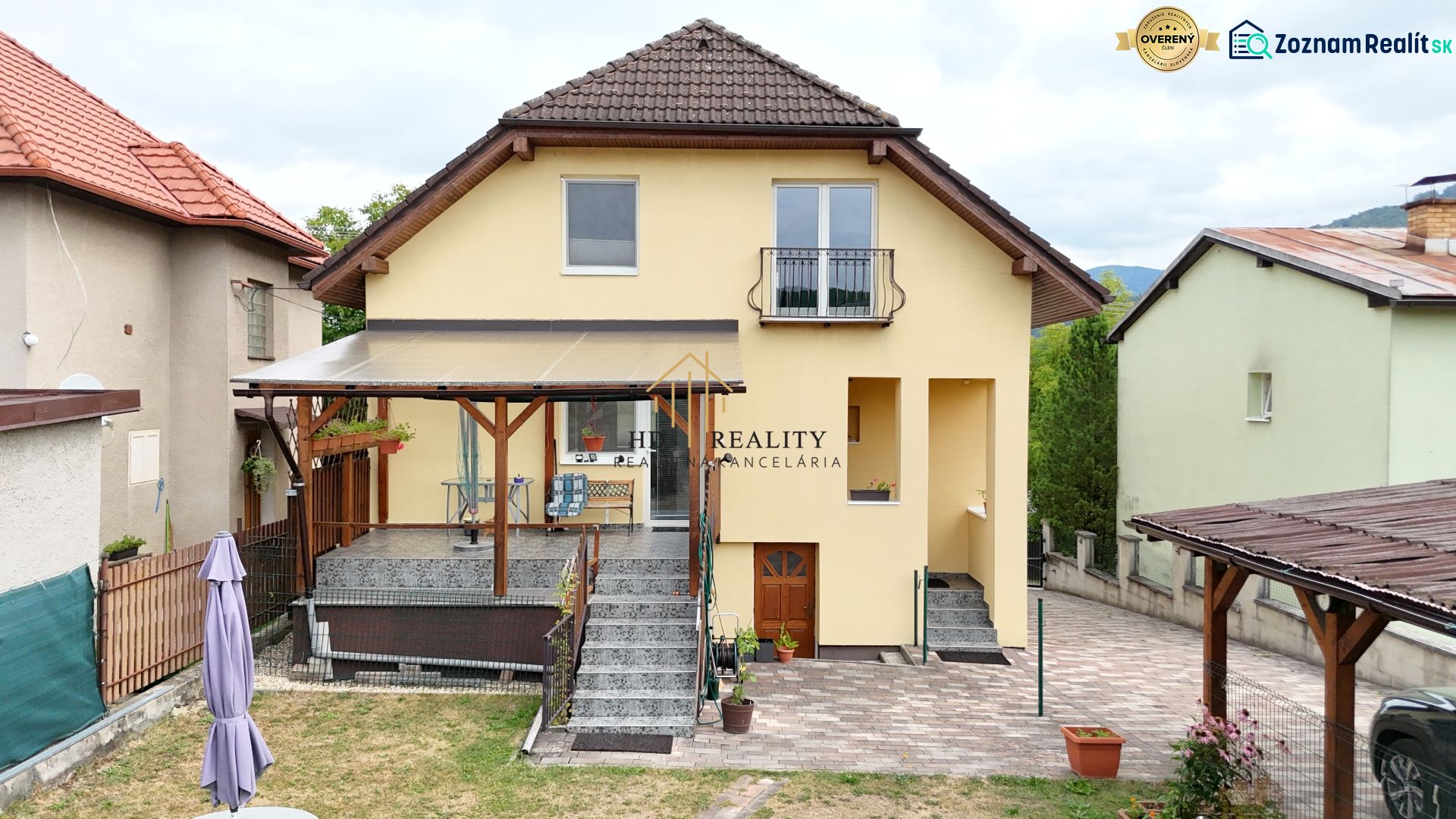 A family house in Medzibrod with a staircase, terrace, and garden among surrounding houses.
