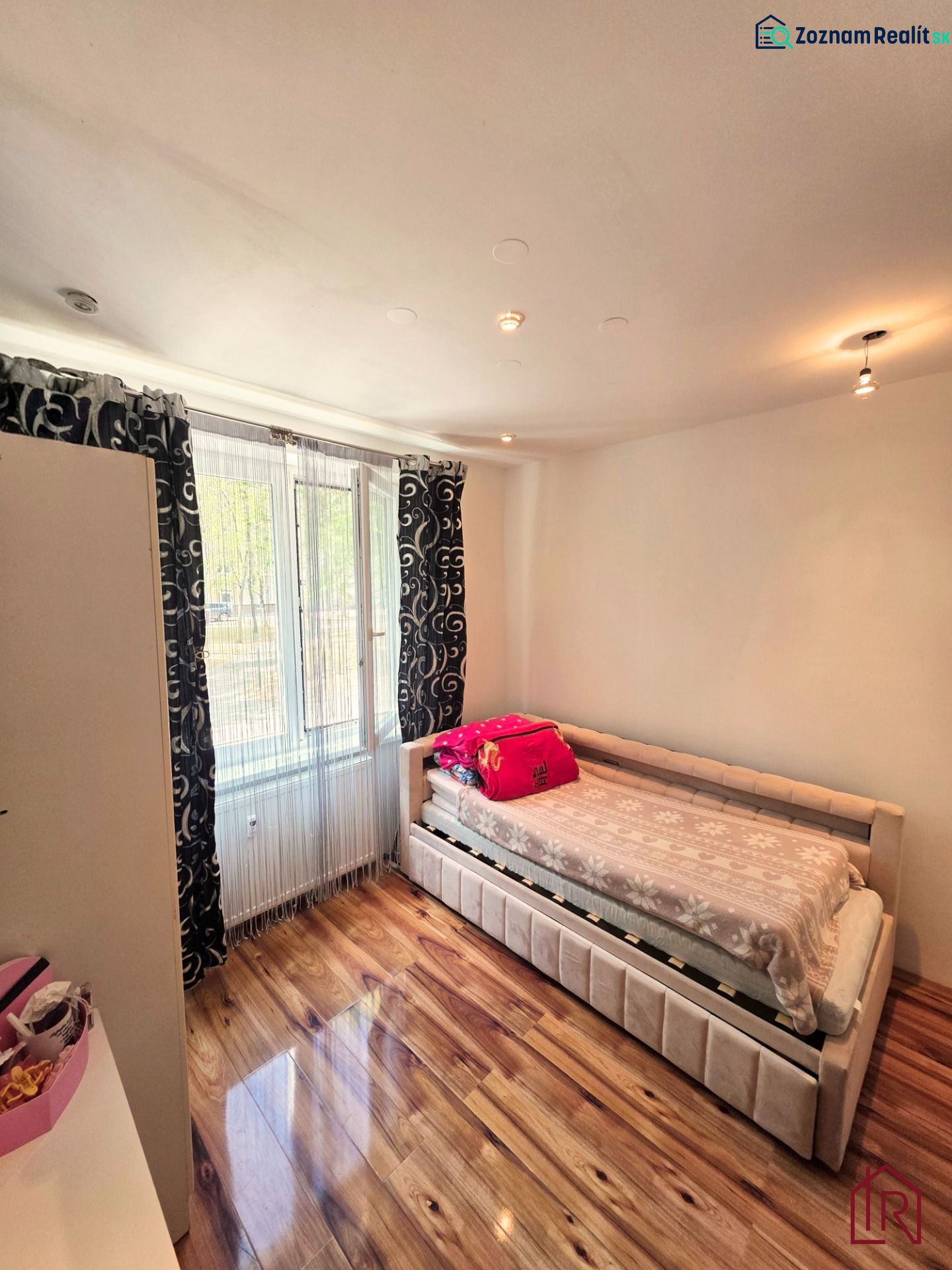 Bedroom in a 4-room apartment with a bed and a wooden decor floor.