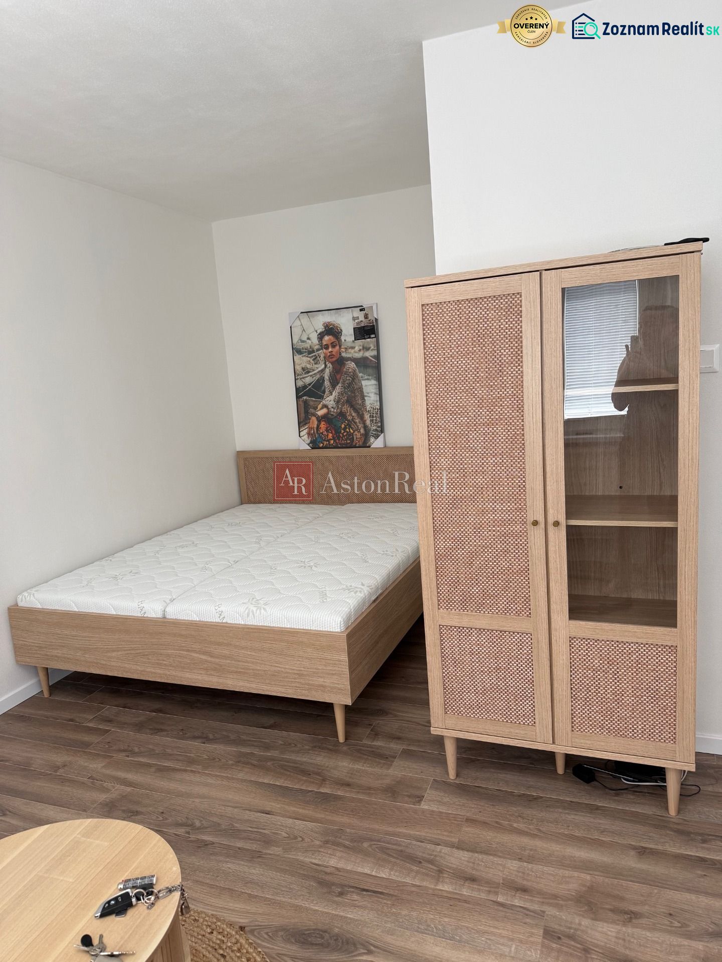 Bed, wardrobe, and floor with wood decor in a studio apartment.
