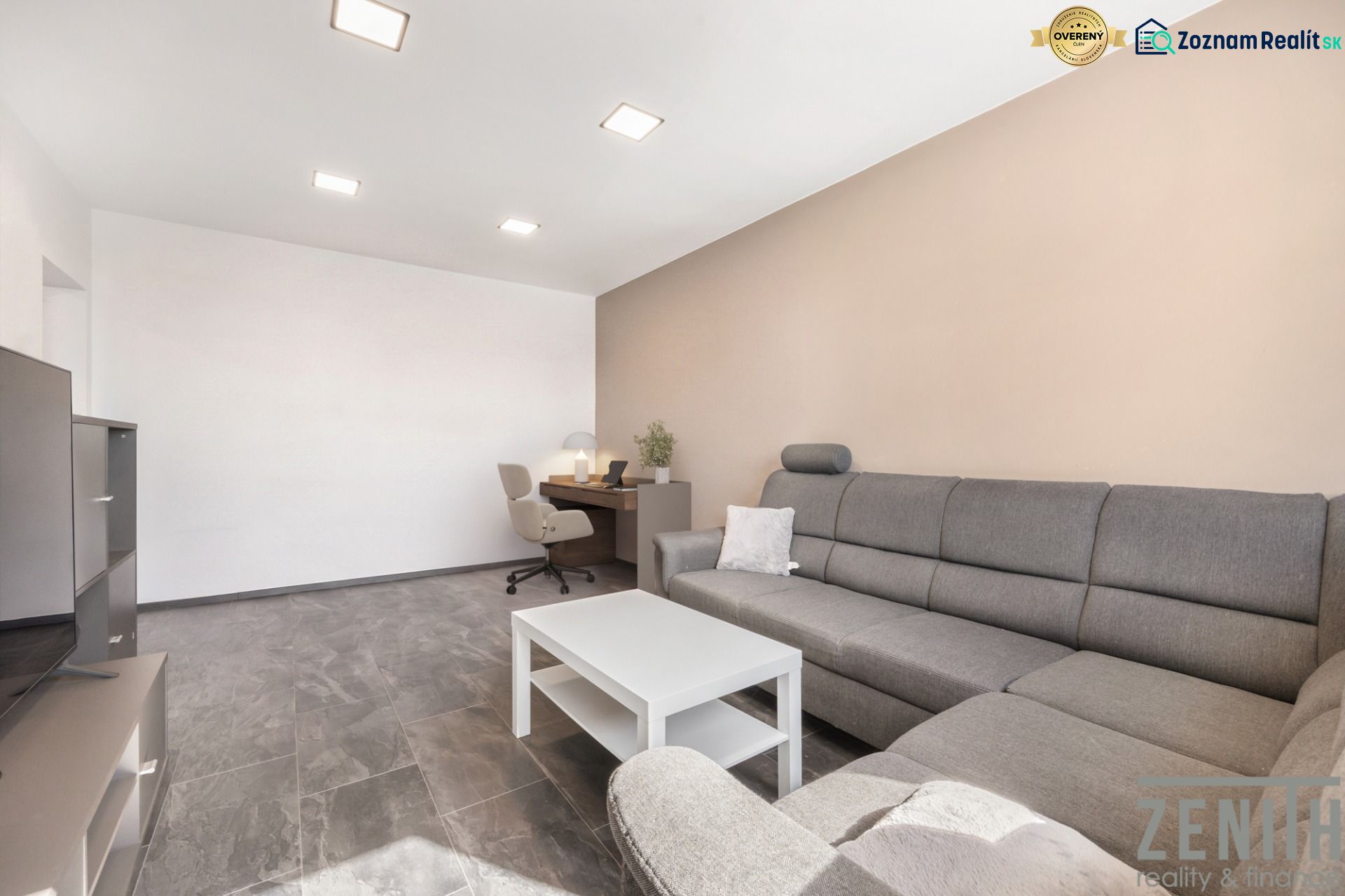 Living room with a gray sofa, a desk, and a coffee table in a two-room apartment.