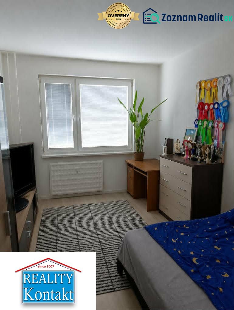 A room in a 2-room apartment with a desk and decorative ribbons on the wall.
