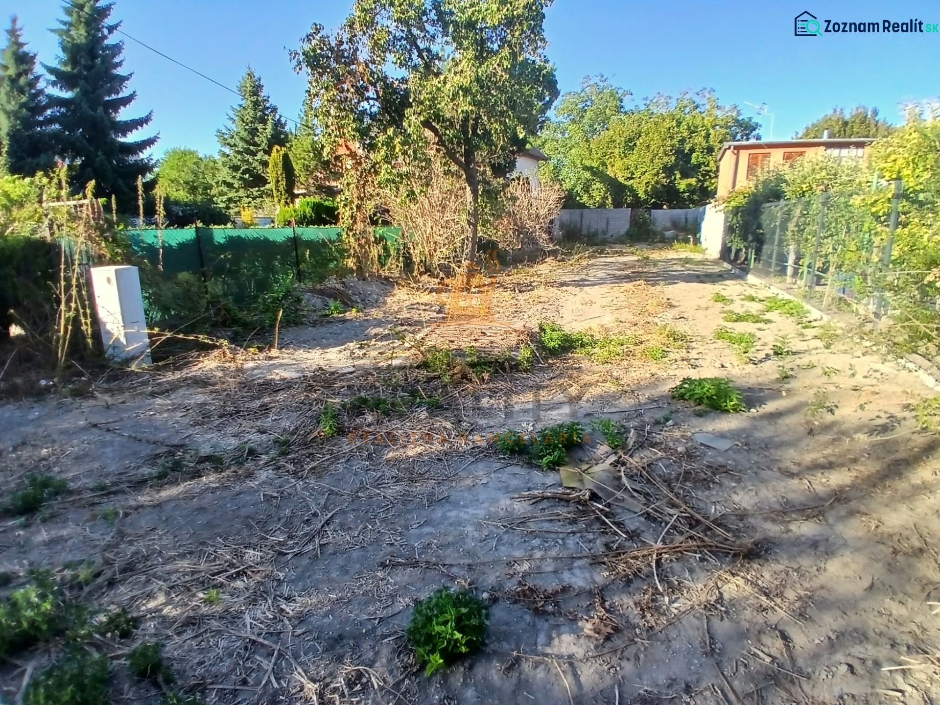 Plots - housing in the village of Vojka nad Dunajom, surrounded by greenery and fences.
