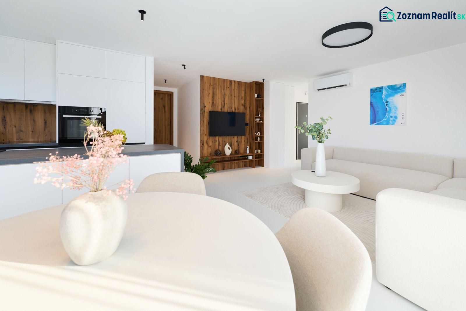 Kitchen and living room of a 4-room apartment with wood-patterned flooring, white interior, and decorations.