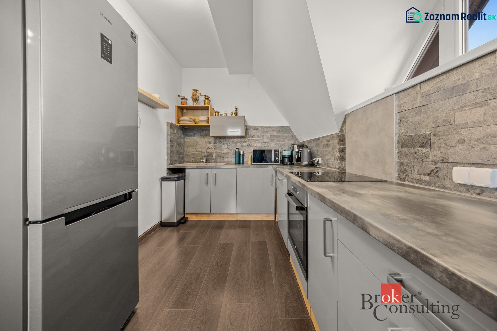 A kitchen with appliances and a wooden decor floor in a 4-room apartment.