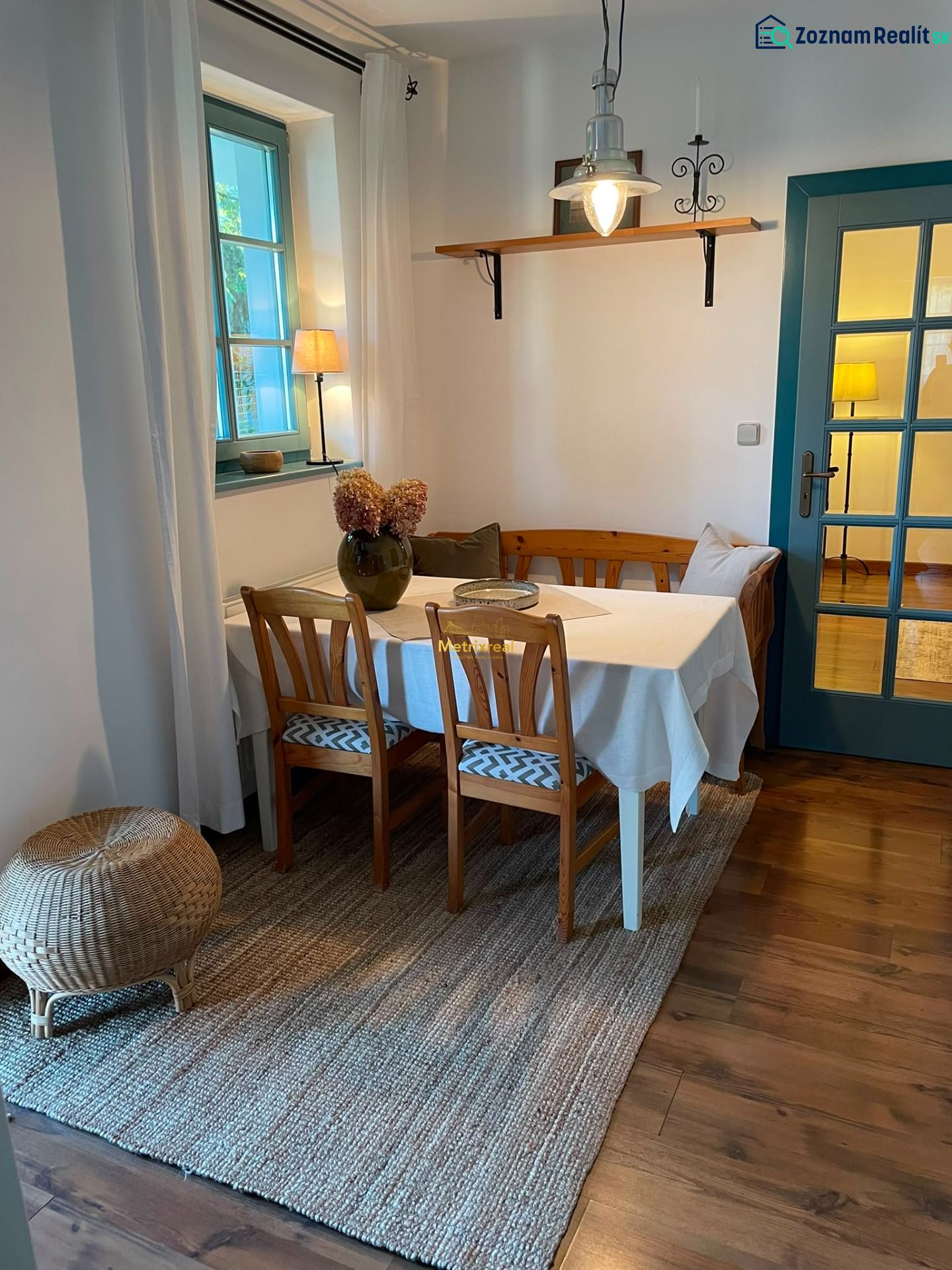 Dining area with wooden furniture and wood-patterned flooring in a family house.