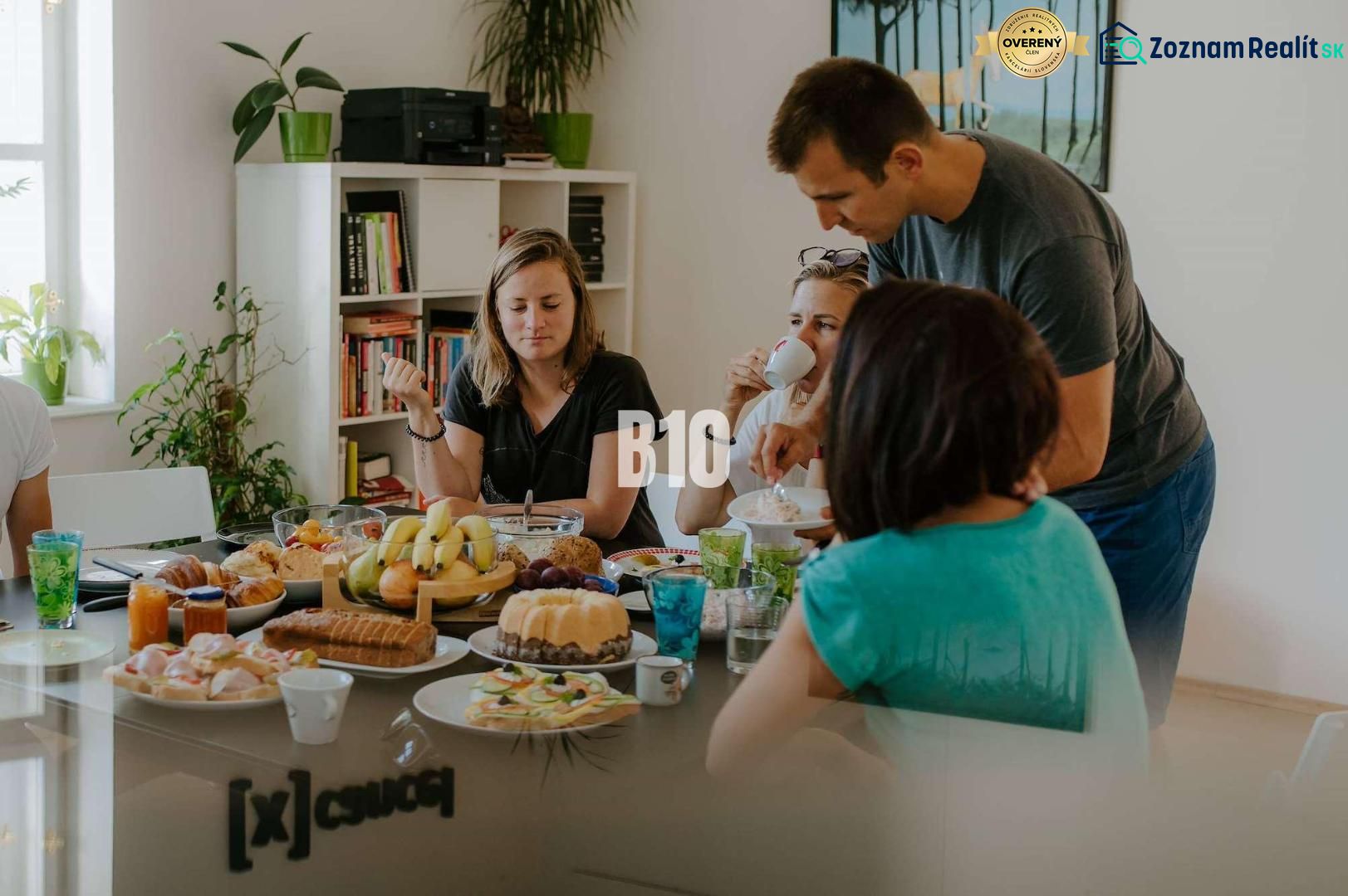 An office with a group of people sitting at a table with snacks and drinks.