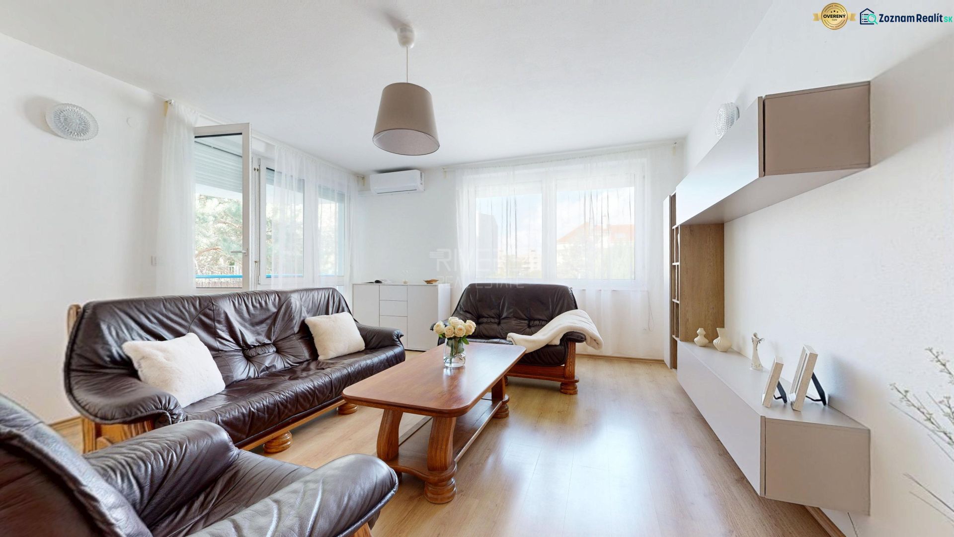 Living room in a 3-room apartment with wooden decor, comfortable sofas, and light.