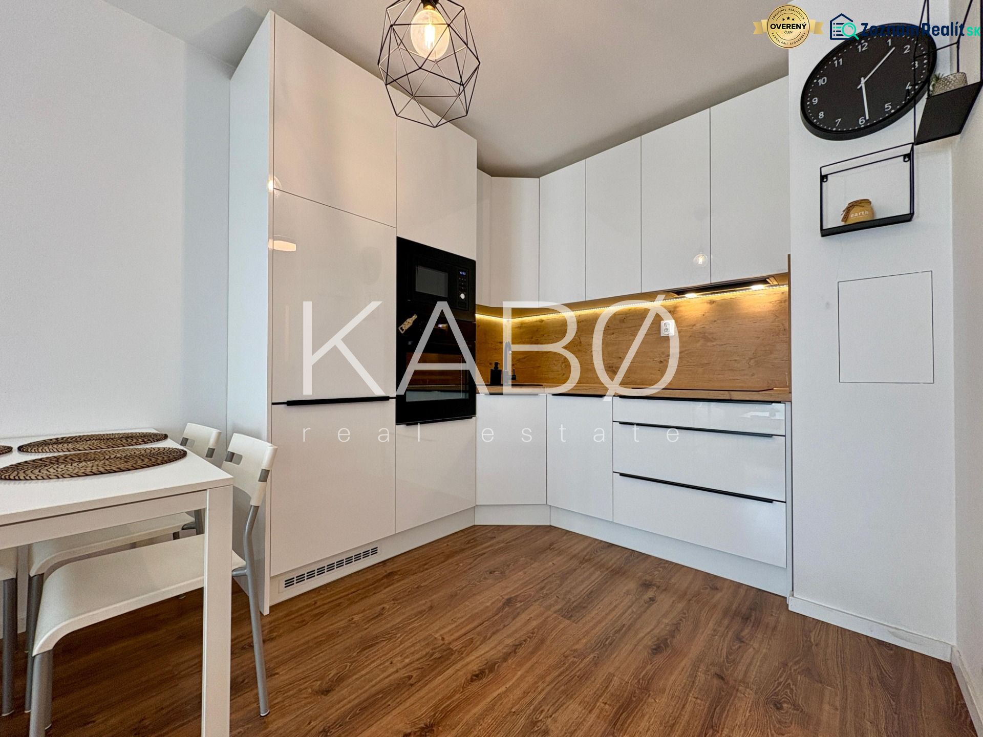 A kitchen in a 2-room apartment with white cabinets and a wood-patterned floor.