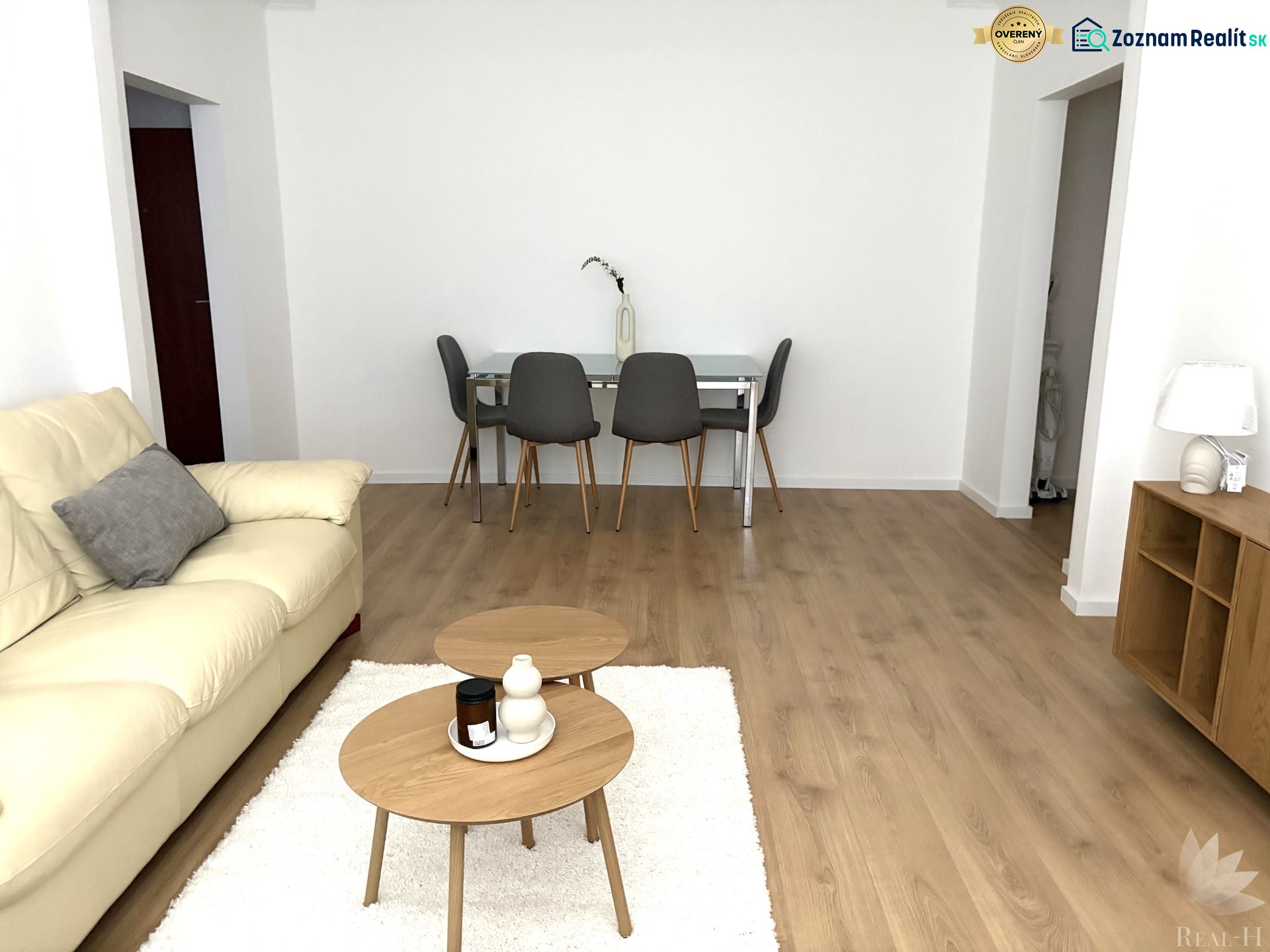 Living room in a 3-room apartment with a cream sofa and a wooden decor floor.