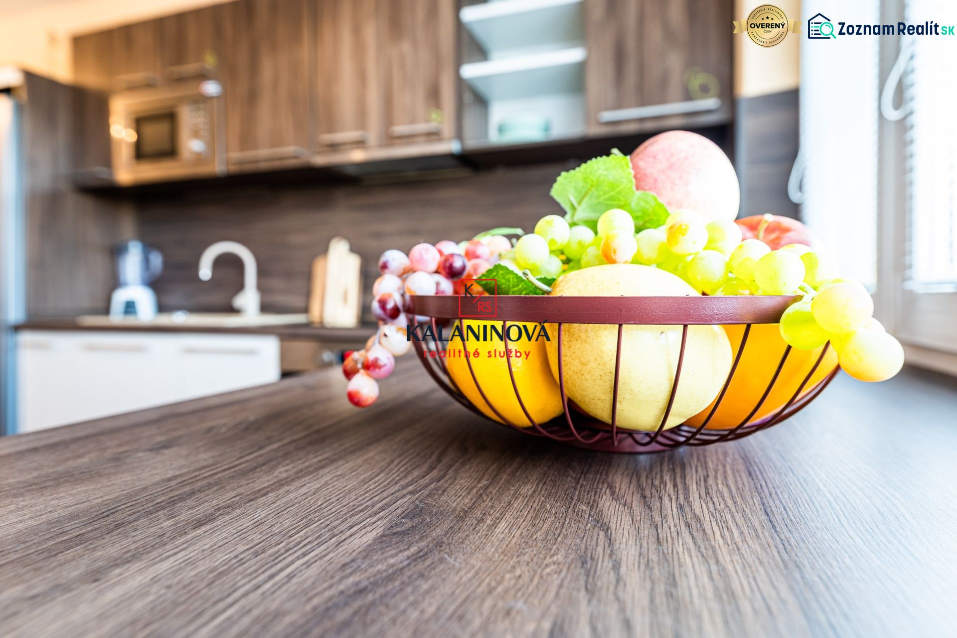 A kitchen in a 2-room apartment with a basket of fruit on the floor with a wooden decor.