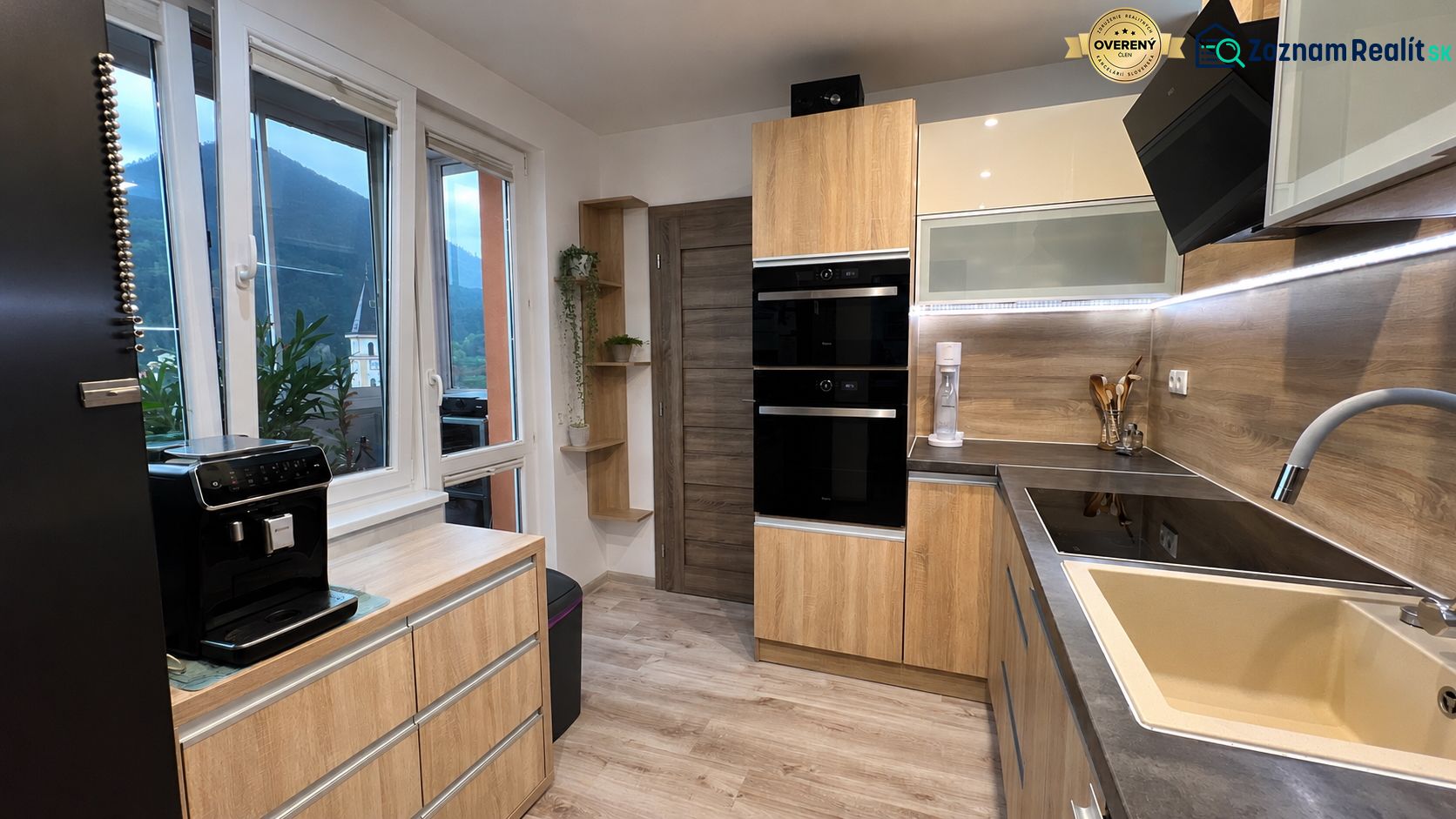 A kitchen in a 3-room apartment with a wooden decor floor and modern equipment.