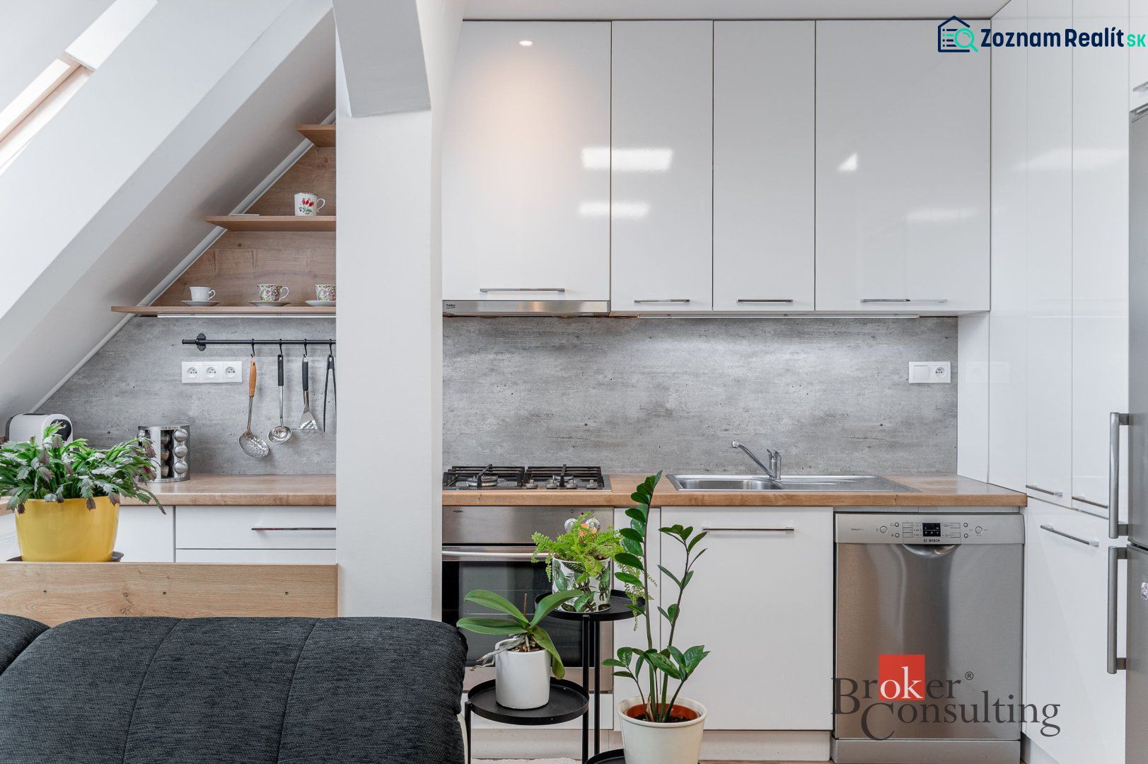 A kitchen corner in a 3-room apartment with plants and cabinets with a glossy finish.
