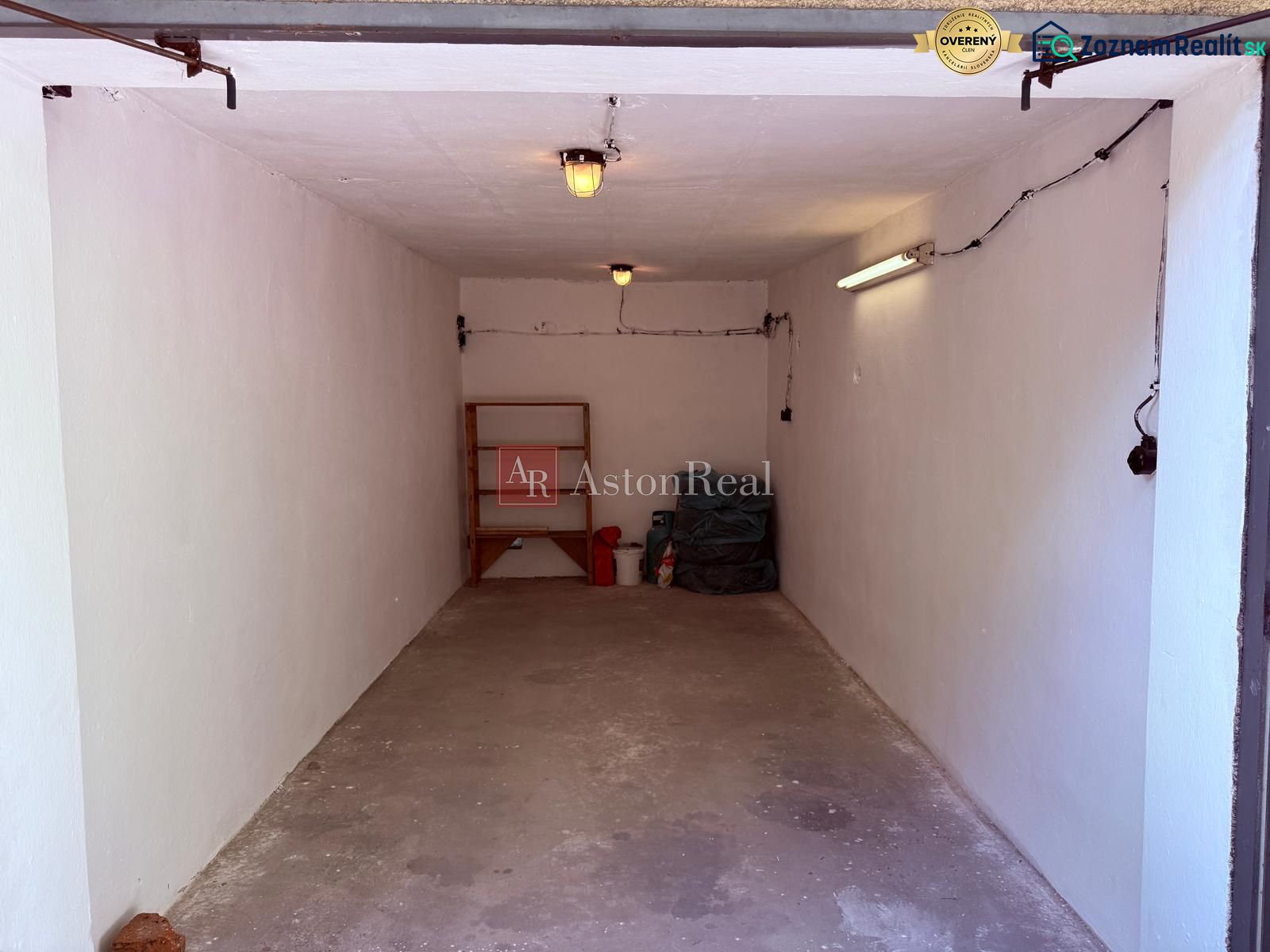 Simply furnished garages on Partizánska Street in Trenčín with shelving and lighting.
