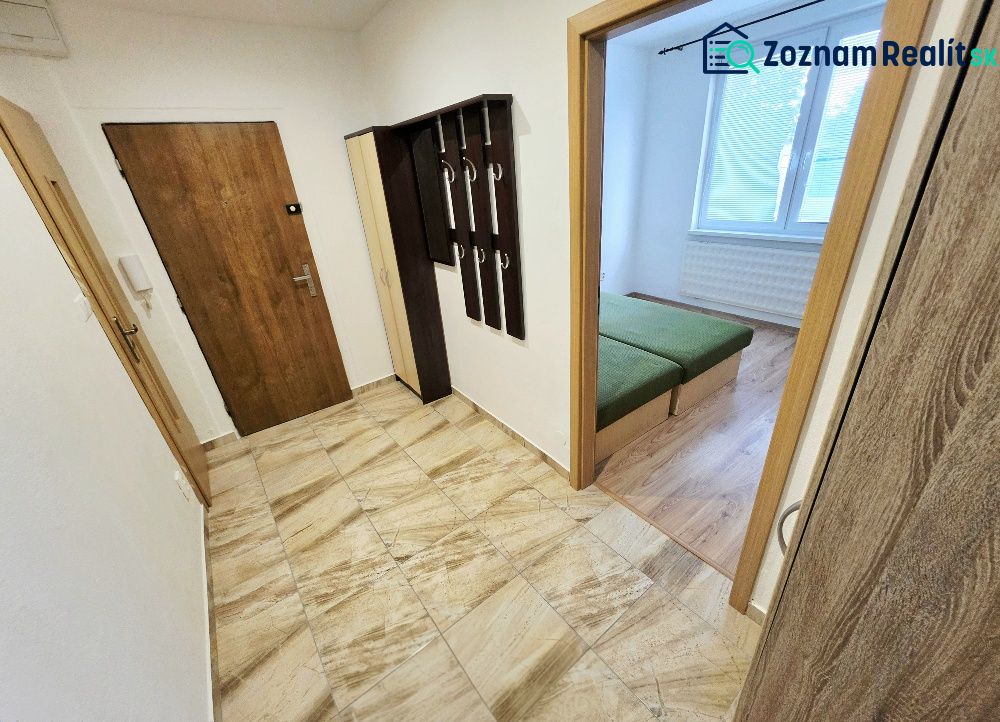 The entrance hall of a 3-room apartment with coat racks and a view into the bedroom.