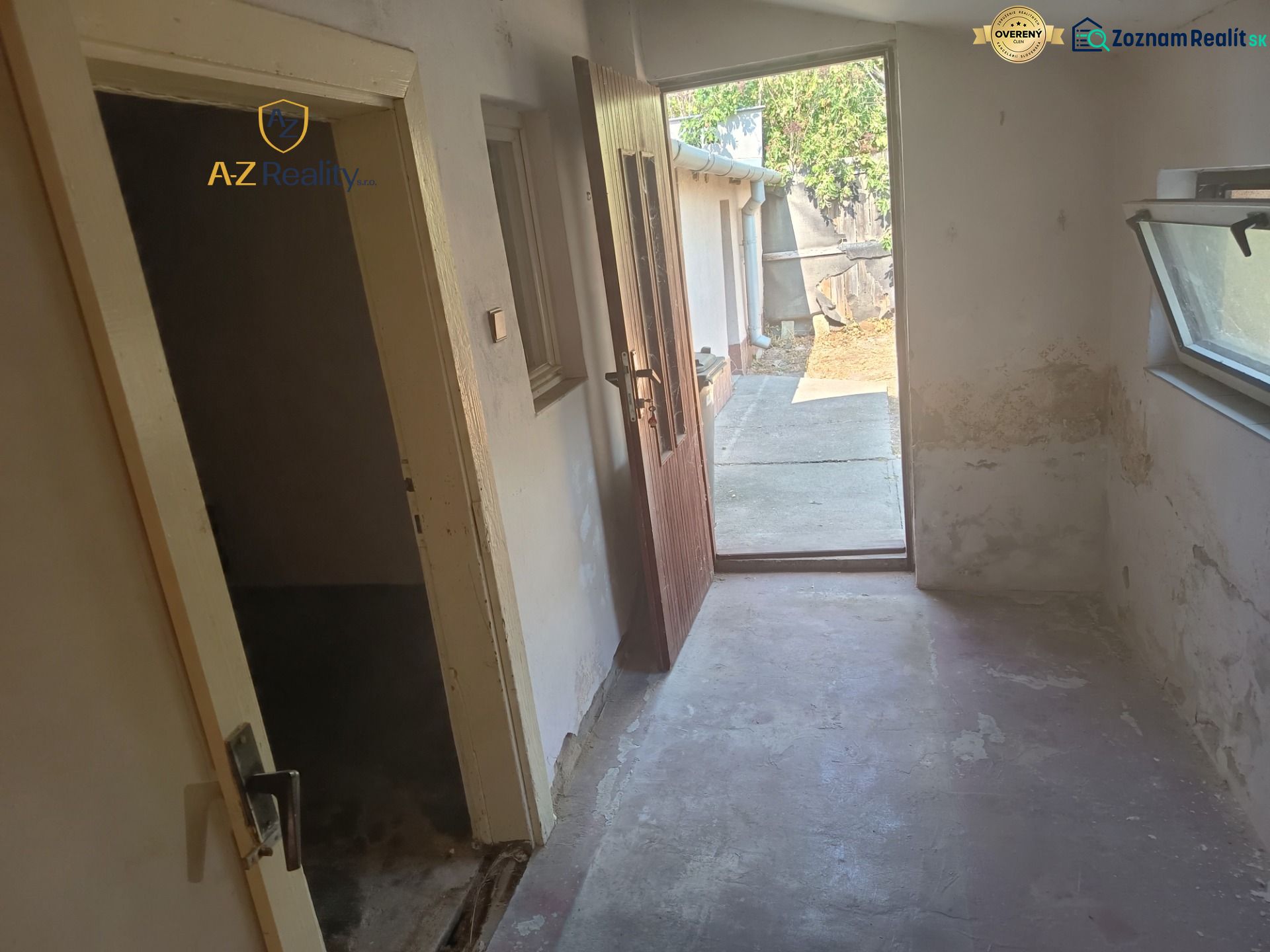 A hallway in a family house with open doors leading to the yard.