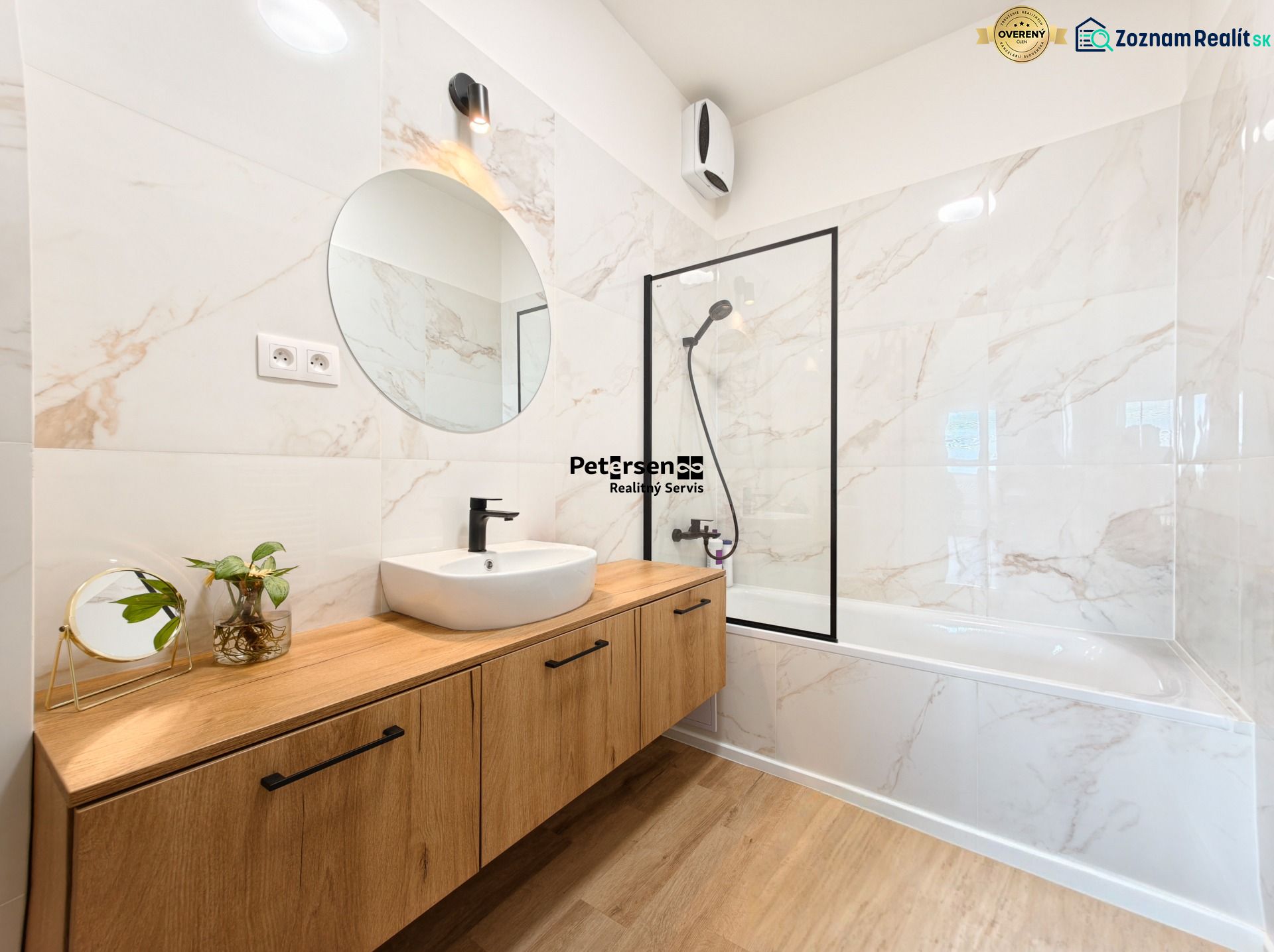 A bathroom in a 4-room apartment with a marble wall and a wooden decor floor.